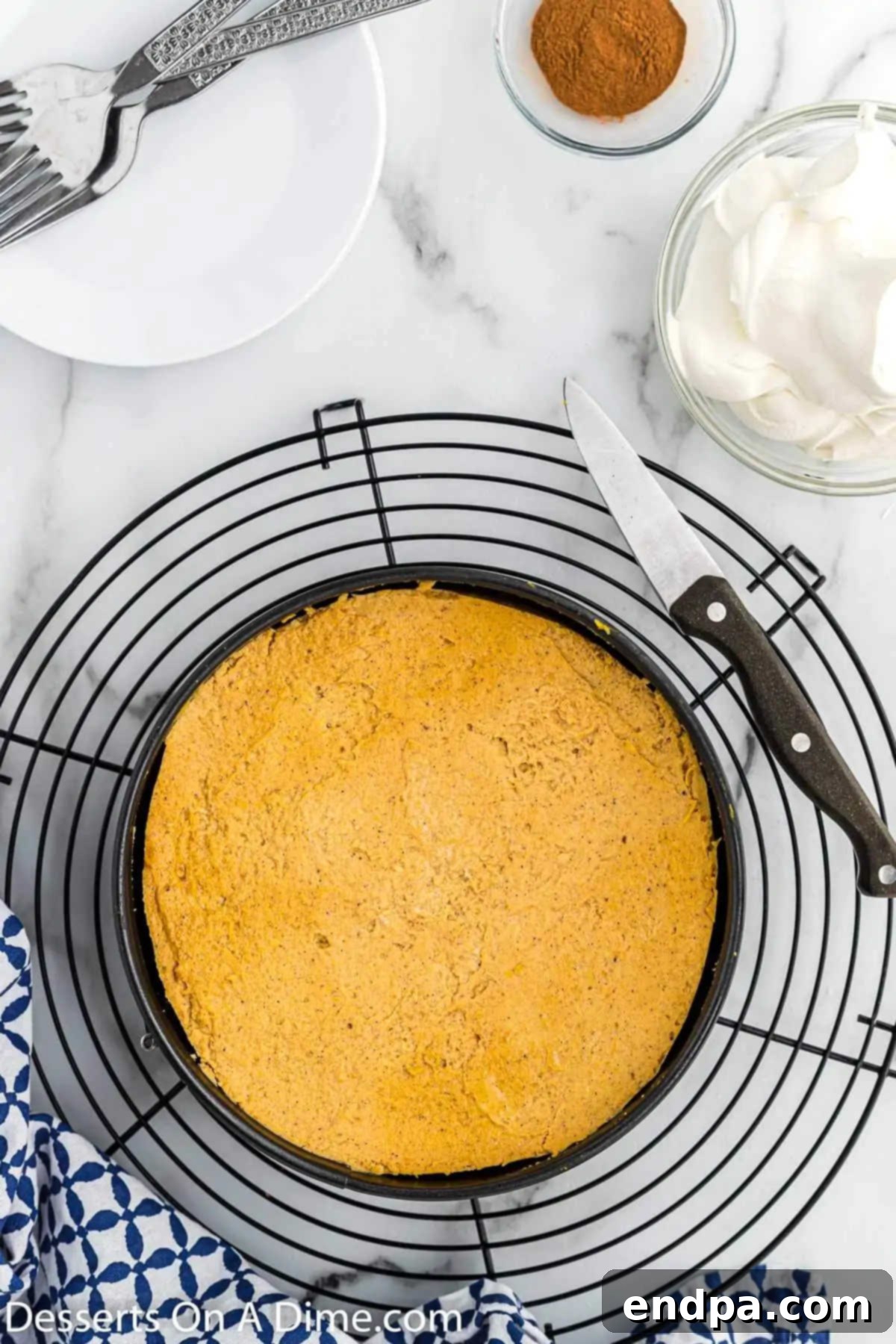 The finished Instant Pot Pumpkin Cheesecake resting on a cooling rack, freshly removed from the pressure cooker.