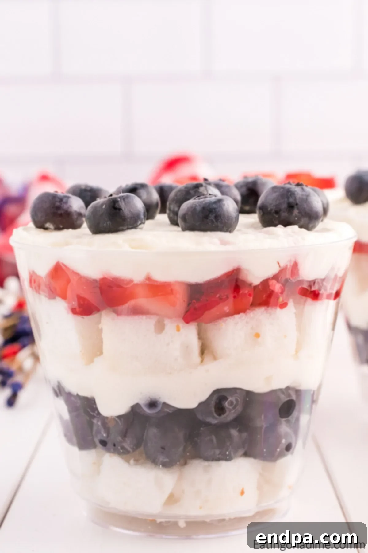 Close up image of layers of angel food cake, strawberries, blueberries and cream all in a mini cup.