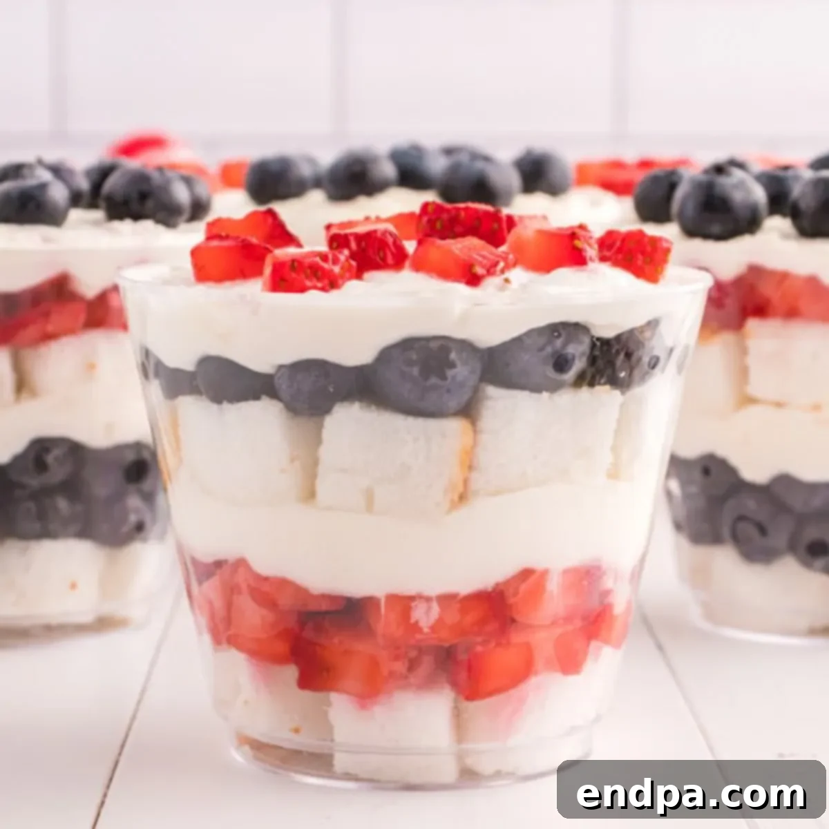 Close up image of layers of angel food cake, strawberries, blueberries and cream all in a mini cup.