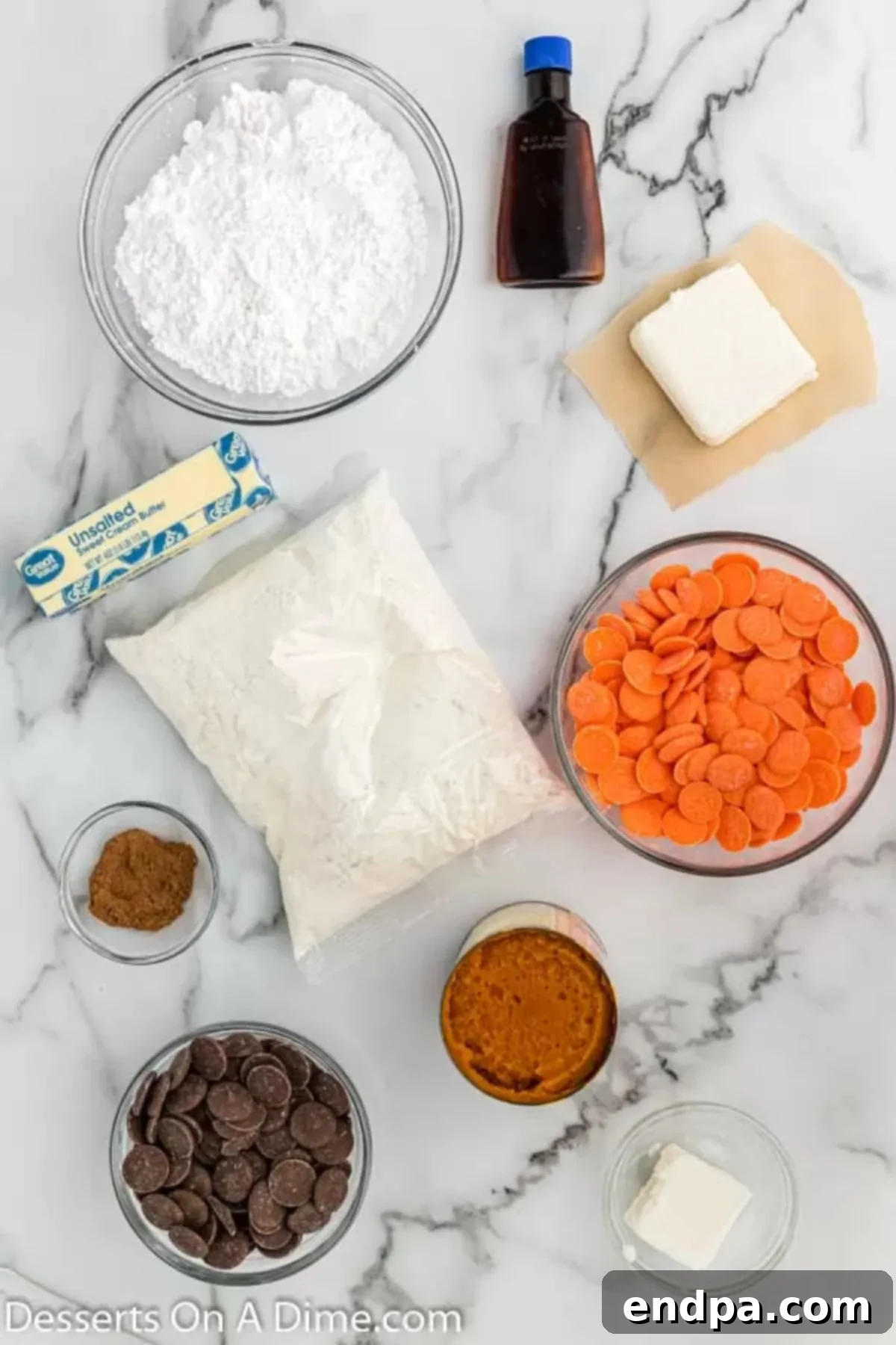 A flat lay of ingredients for pumpkin cake pops including yellow cake mix, pumpkin puree, pumpkin spice, butter, cream cheese, powdered sugar, orange candy melts, chocolate candy melts, and vegetable shortening.