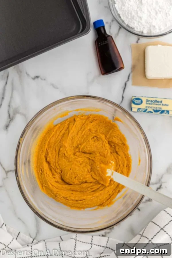 Mixing bowl with yellow cake mix, pumpkin puree, and pumpkin pie spice combined.