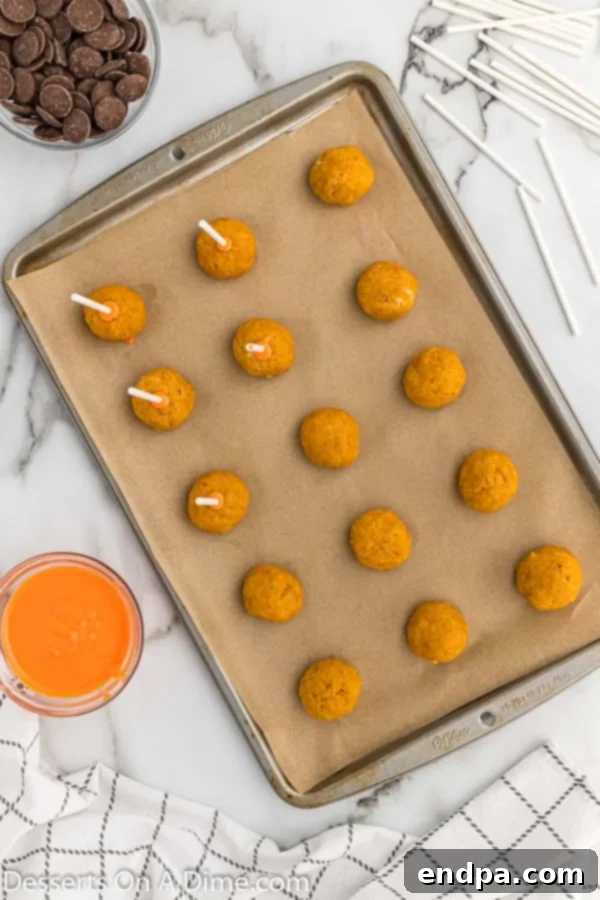 Lollipop sticks dipped in candy melts and inserted into cake pops, ready for chilling.