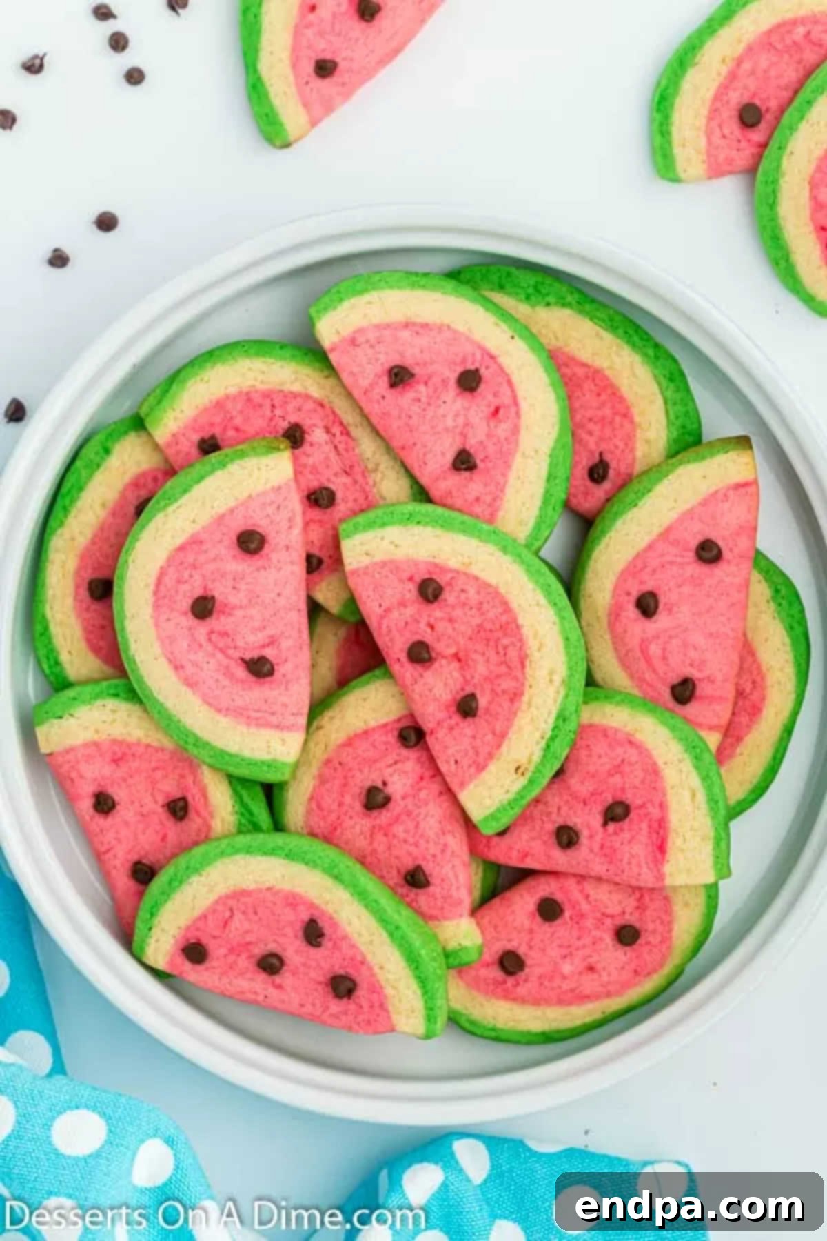 Summer Melon Bites 12 An inviting close-up of baked watermelon cookies on a plate, showcasing their vibrant colors and chocolate chip 'seeds'.