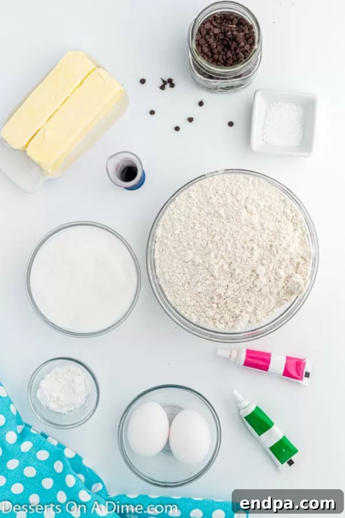 Summer Melon Bites 3 A colorful array of ingredients for Watermelon Cookies, including flour, butter, vanilla extract, various food colorings, and mini chocolate chips.