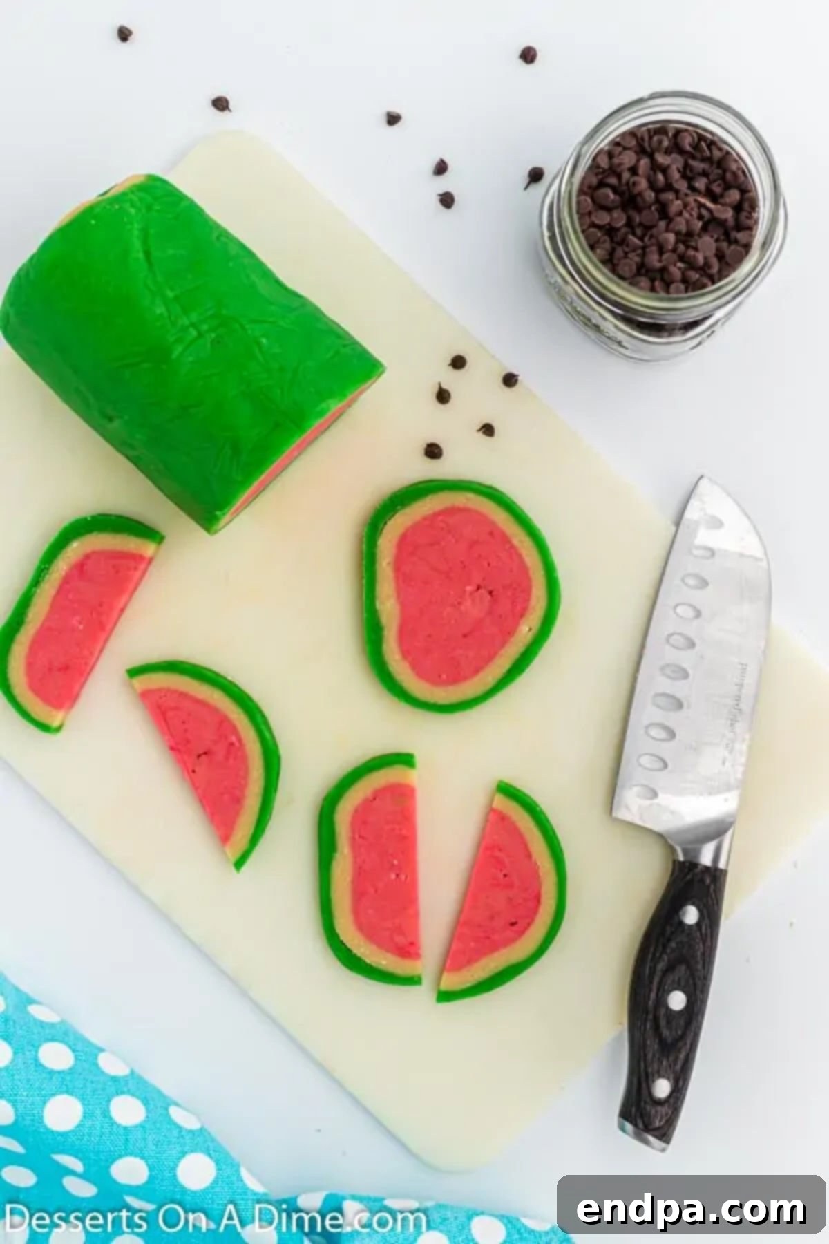Summer Melon Bites 9 Watermelon cookie slices carefully arranged on a baking sheet, with some cut into half-moon shapes.