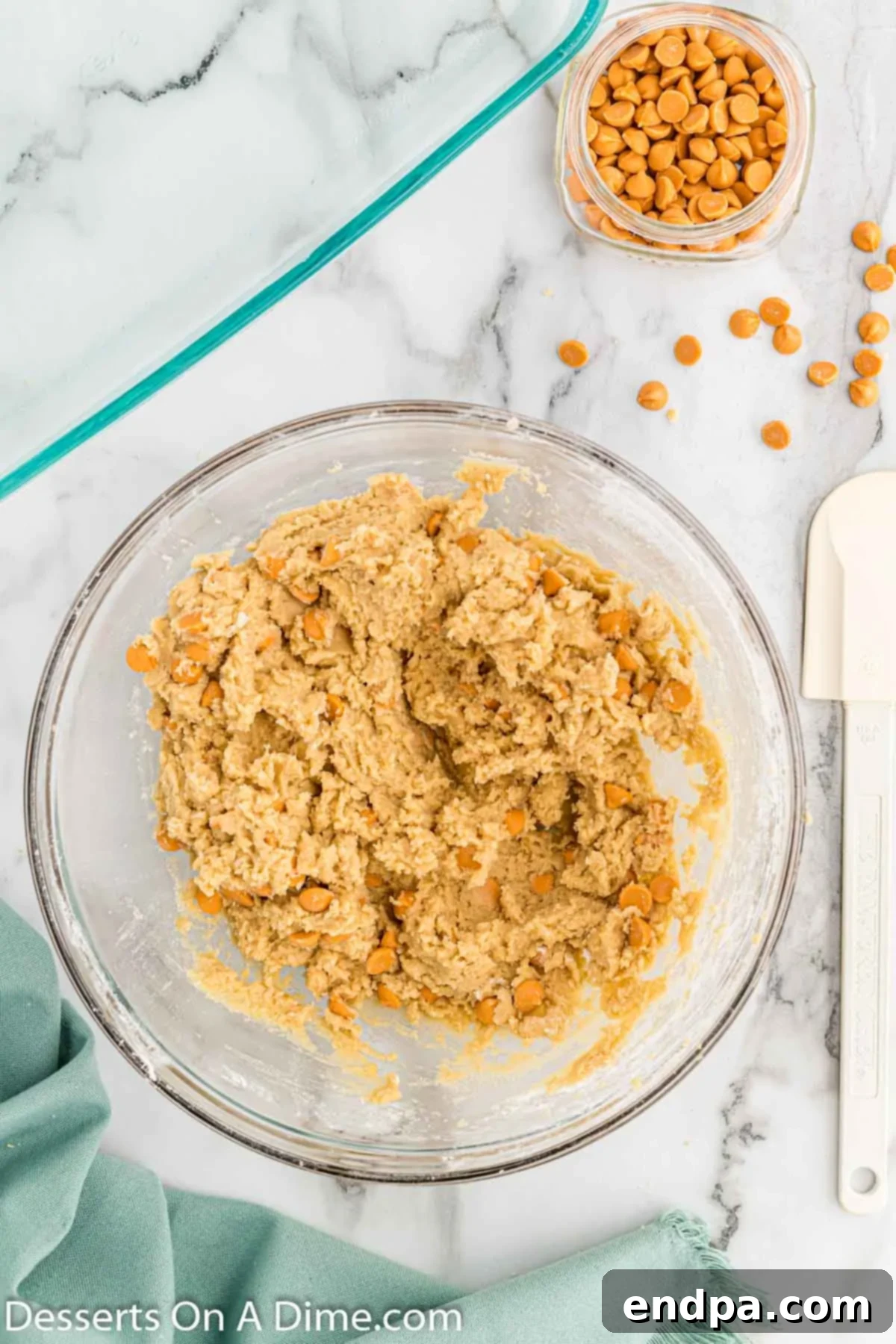 Irresistible Butterscotch Squares 7 Butterscotch chips being gently folded into the bar batter with a spatula.