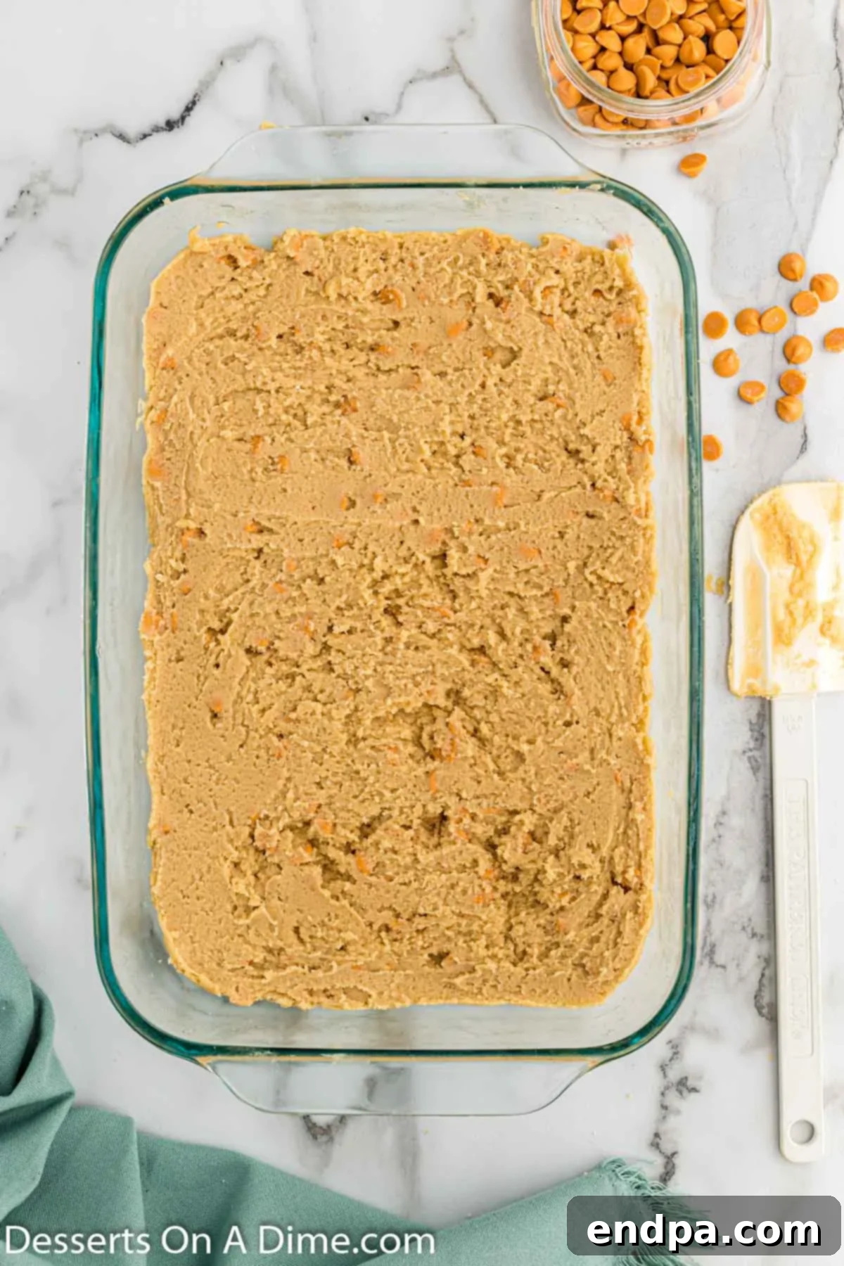 Irresistible Butterscotch Squares 8 The butterscotch bar batter being spread evenly into a prepared 9x13 inch baking pan.