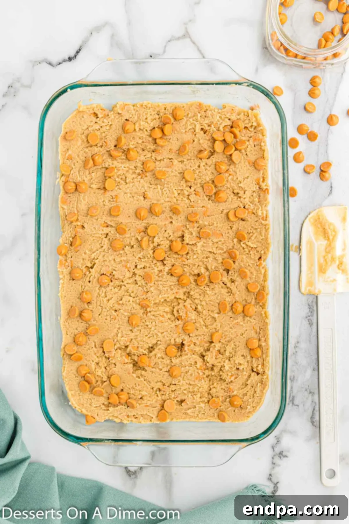 Irresistible Butterscotch Squares 9 Remaining butterscotch chips being sprinkled over the top of the batter in the pan.