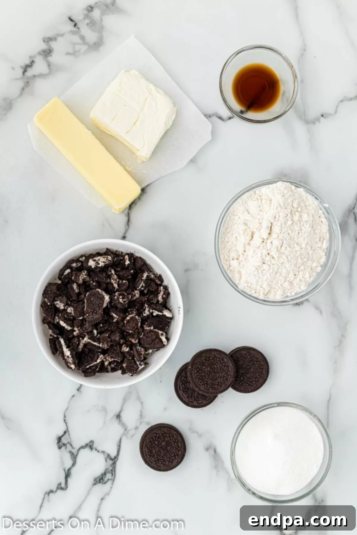 Key ingredients for Oreo cheesecake cookies displayed on a counter: cream cheese, butter, granulated sugar, all-purpose flour, vanilla extract, and Oreo cookies.