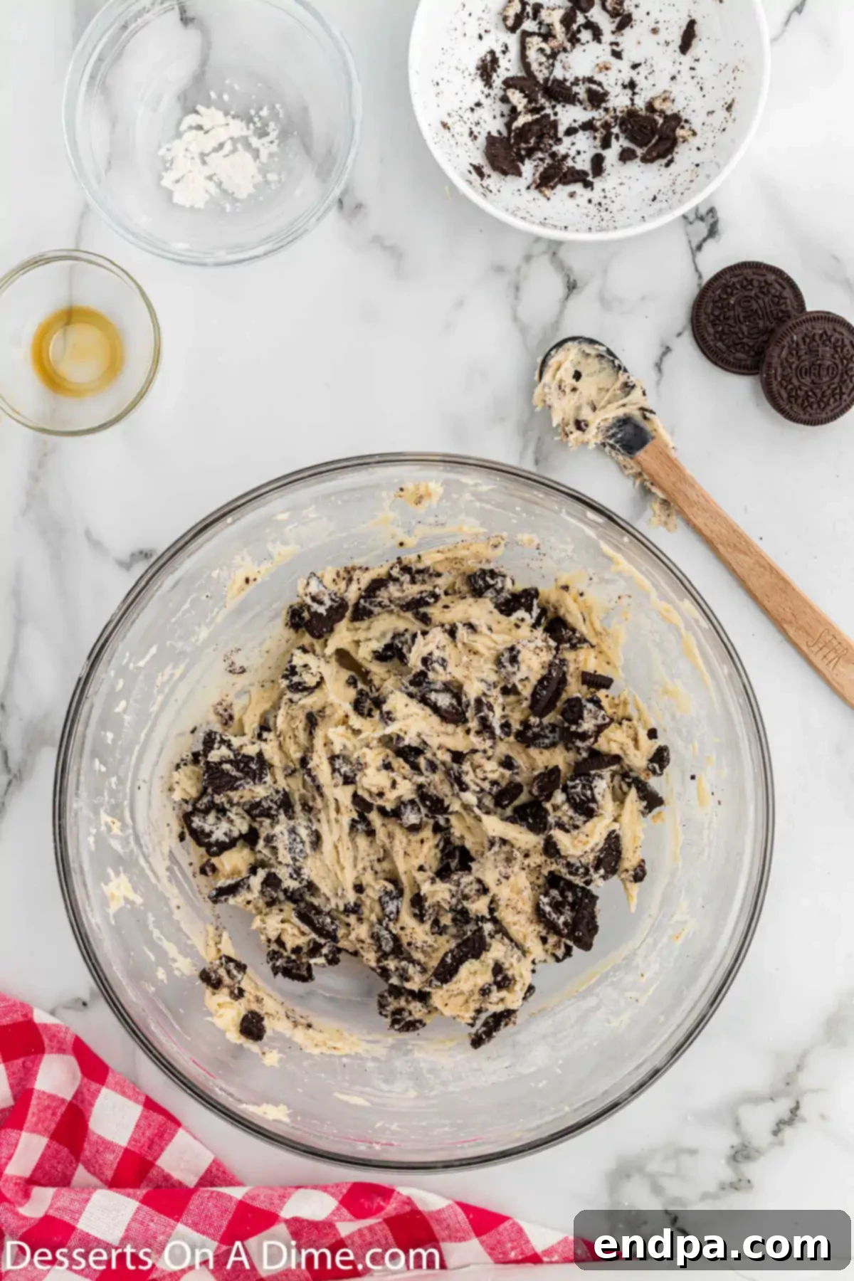 Coarsely chopped Oreo cookies being folded into the prepared cookie dough.