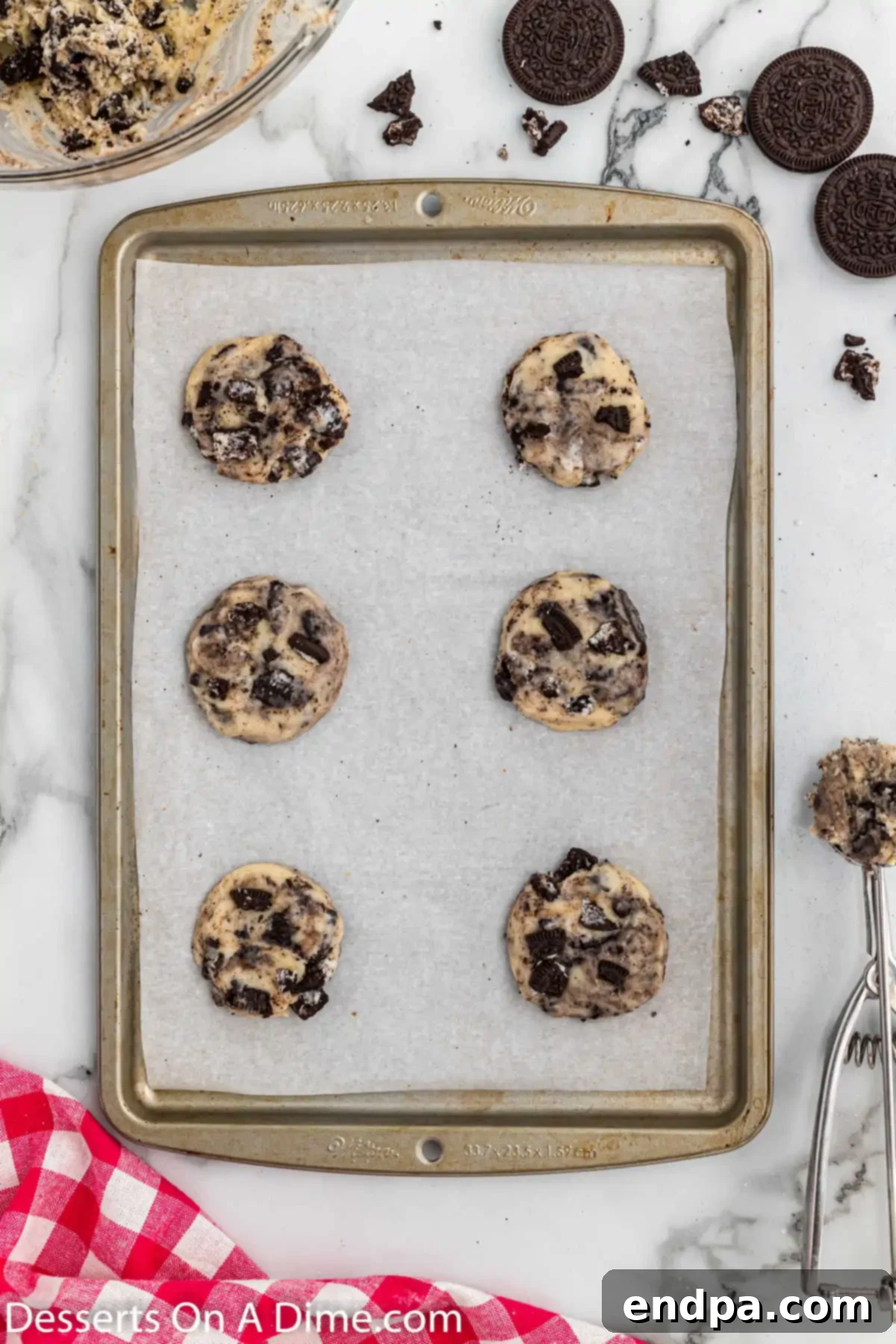 Portioned cookie dough balls arranged on a baking sheet, ready for chilling and baking.