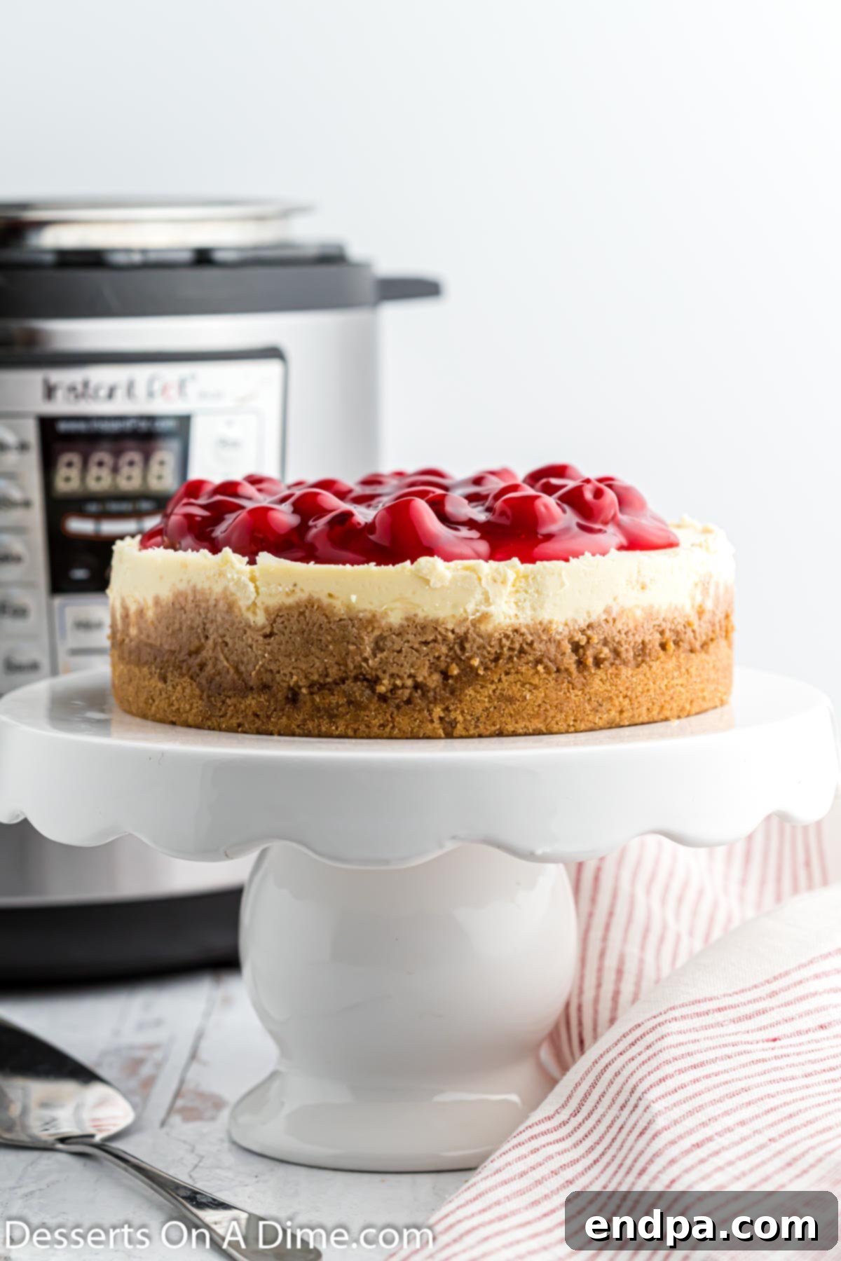A luscious Instant Pot cheesecake generously topped with vibrant cherry pie filling, ready to be served.