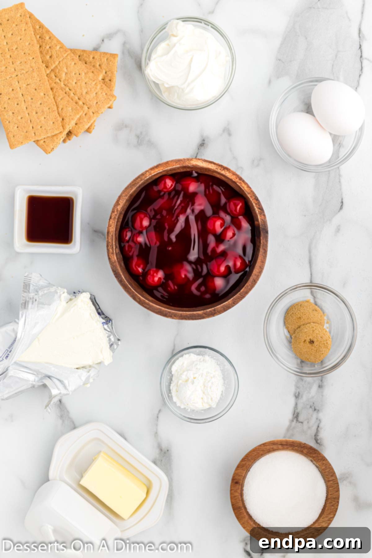 Various ingredients laid out for making Instant Pot cheesecake, including graham crackers, cream cheese, and butter.