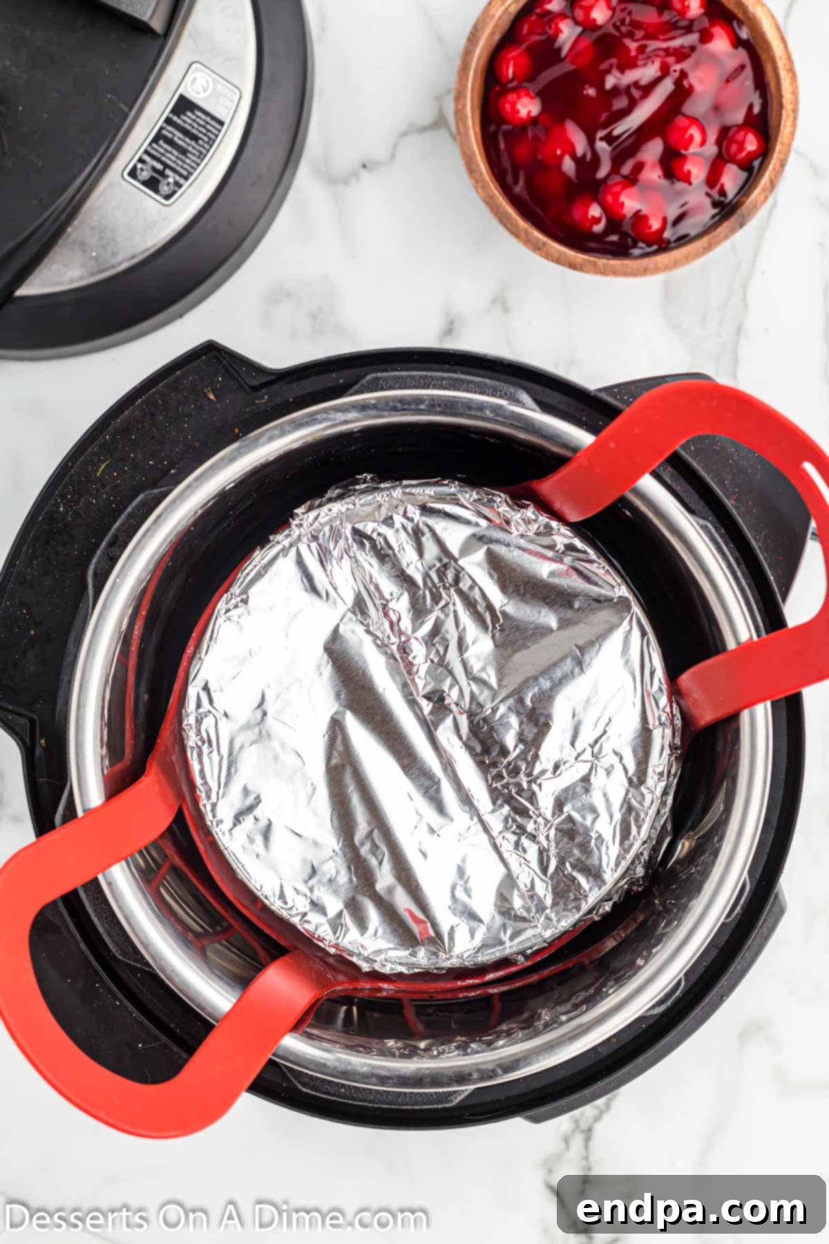 The cheesecake pan covered with aluminum foil, placed on a trivet inside the Instant Pot.