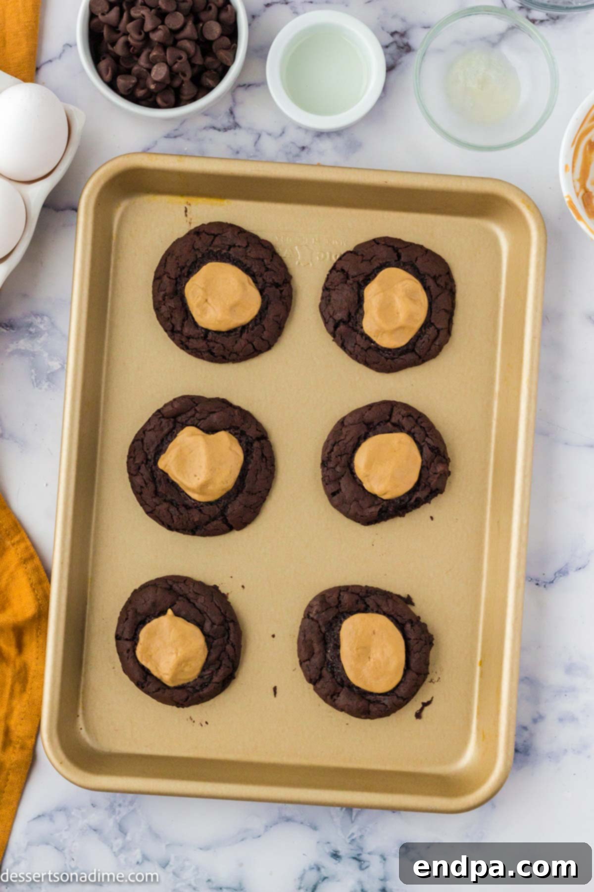 Ultimate Buckeye Brownie Delights 9 Baked Buckeye Brownie Cookies, golden brown around the edges, cooling on a baking sheet.