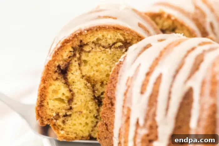 A beautiful Cinnamon Bundt Cake with a delicate glaze, showing its cinnamon swirl interior.