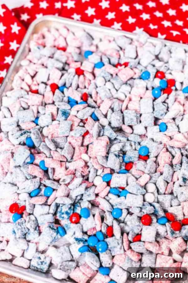 Patriotic Puppy Chow 6 Blue-coated cereal tossed in powdered sugar and spread on a baking sheet to cool.