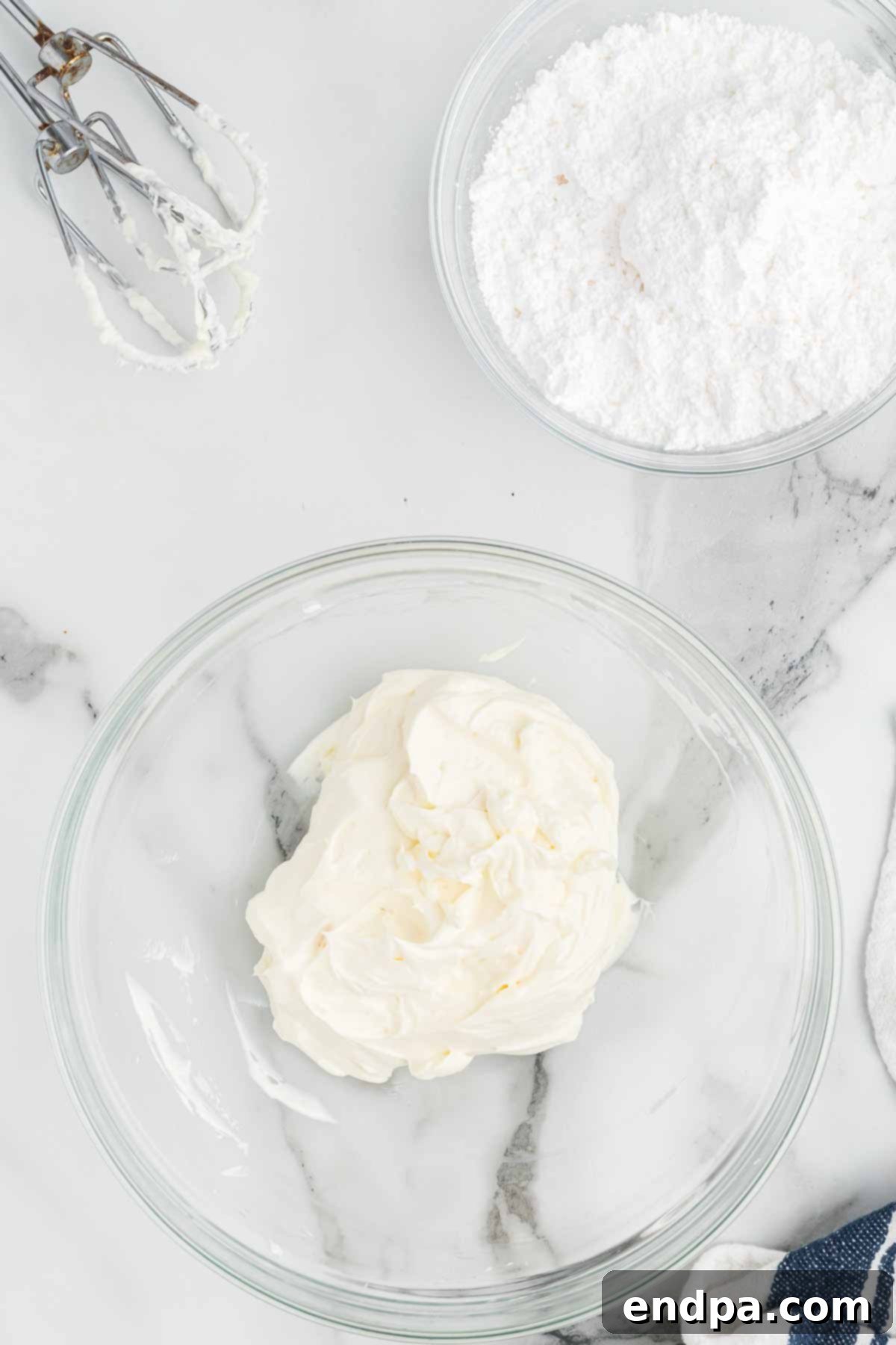 A block of softened cream cheese placed in a large mixing bowl, ready to be beaten.