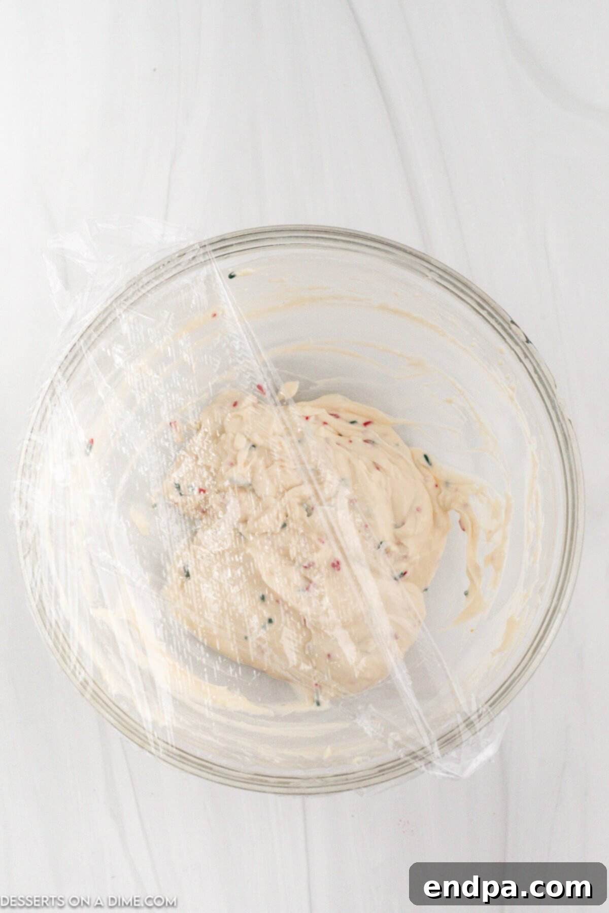 Santa's Favorite Cookie Dip 6 Step 3: Gently folding in Christmas sprinkles, reserving some for garnish.