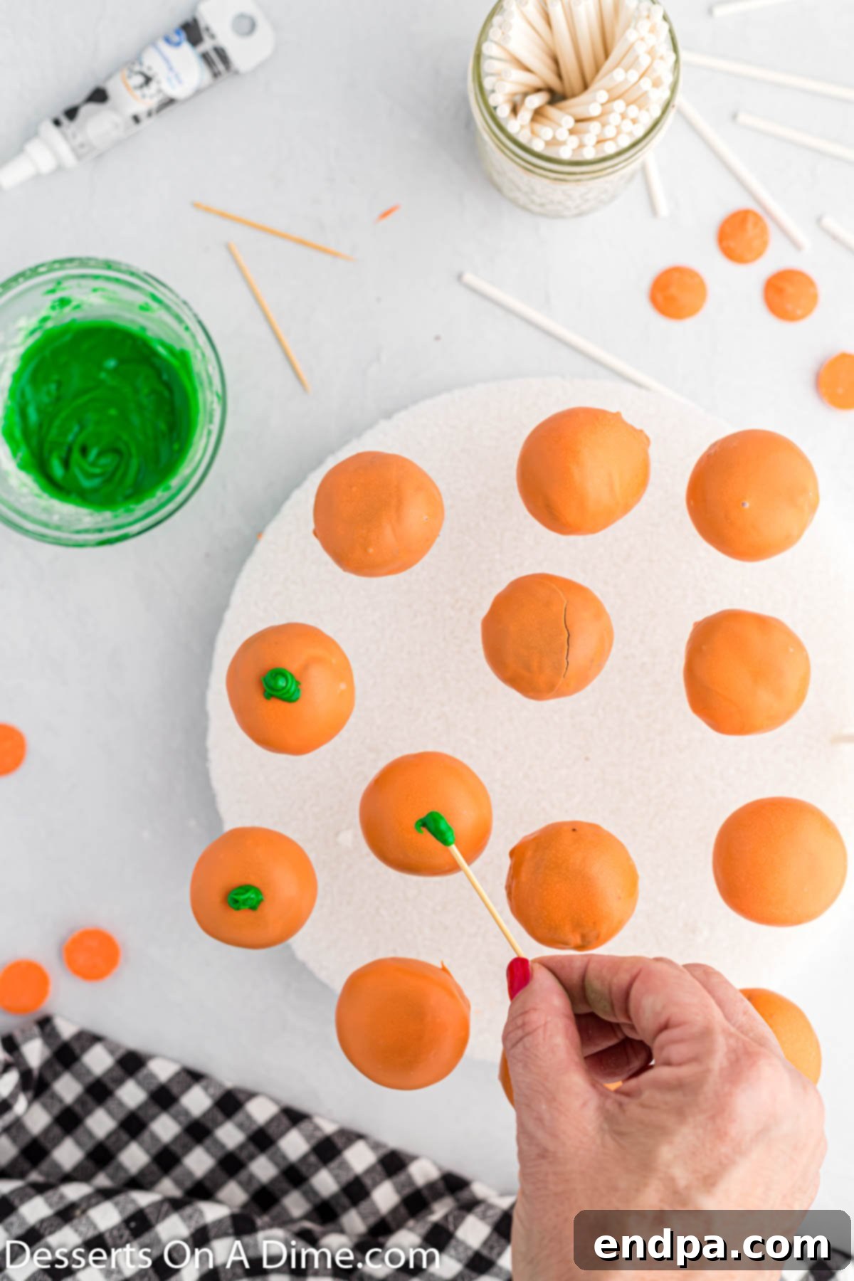 Spooky Sweet Halloween Cake Pops 7 Dipping cake pops into melted orange candy melts and then decorating them.