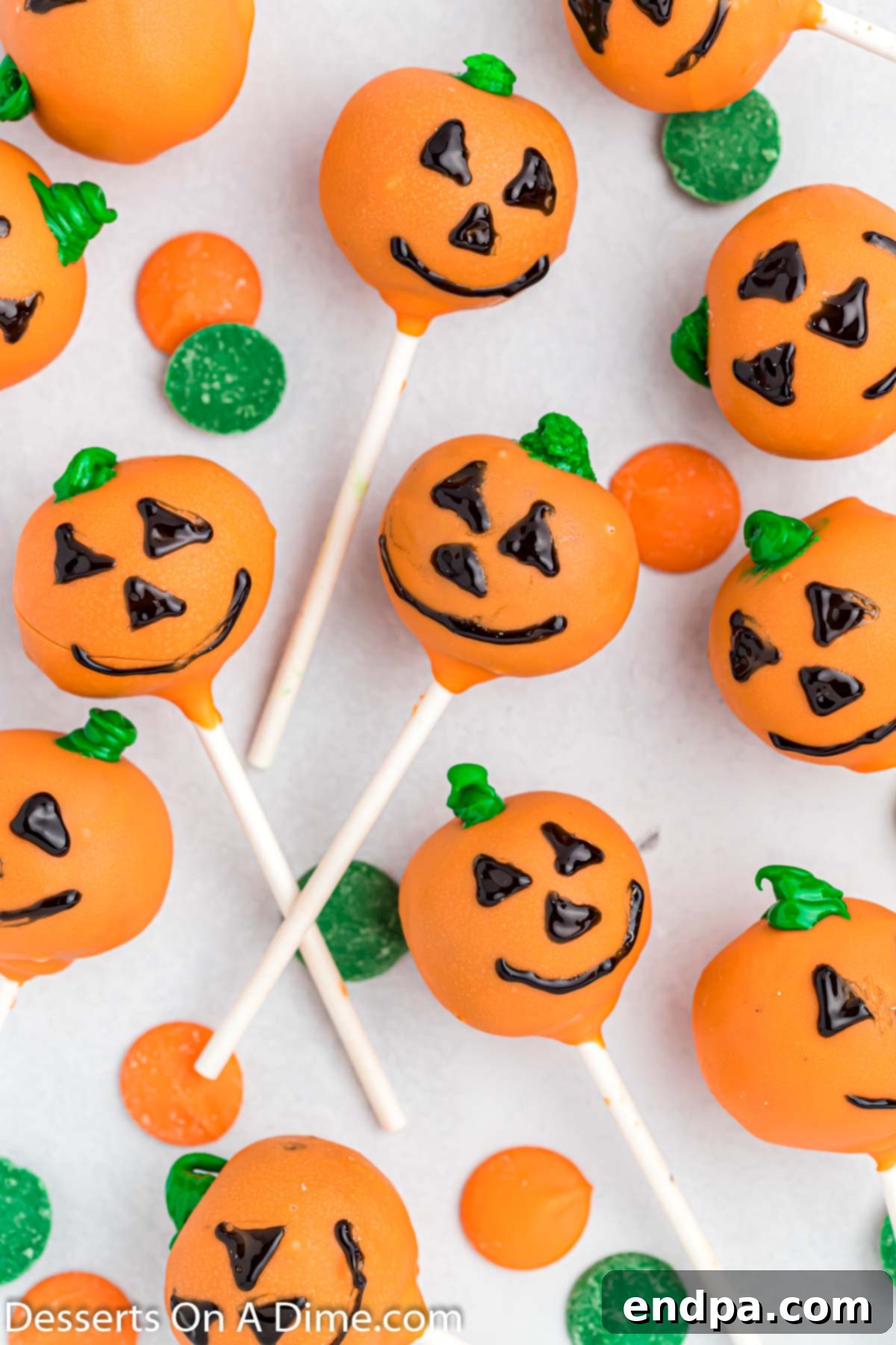 Spooky Sweet Halloween Cake Pops 8 Close-up photo of several decorated Halloween cake pops, depicting various Jack-o'-Lantern faces.