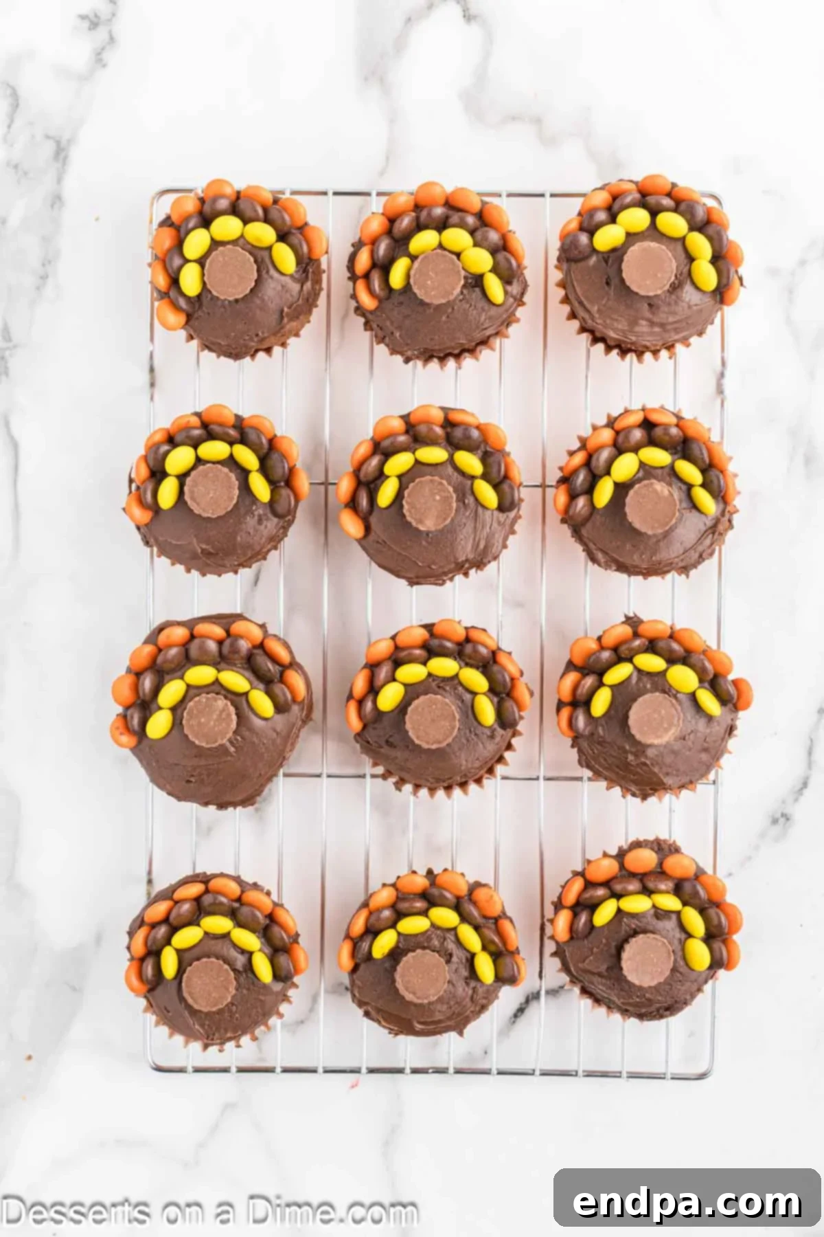A mini Reese's Peanut Butter Cup gently pressed into the center of a frosted cupcake.