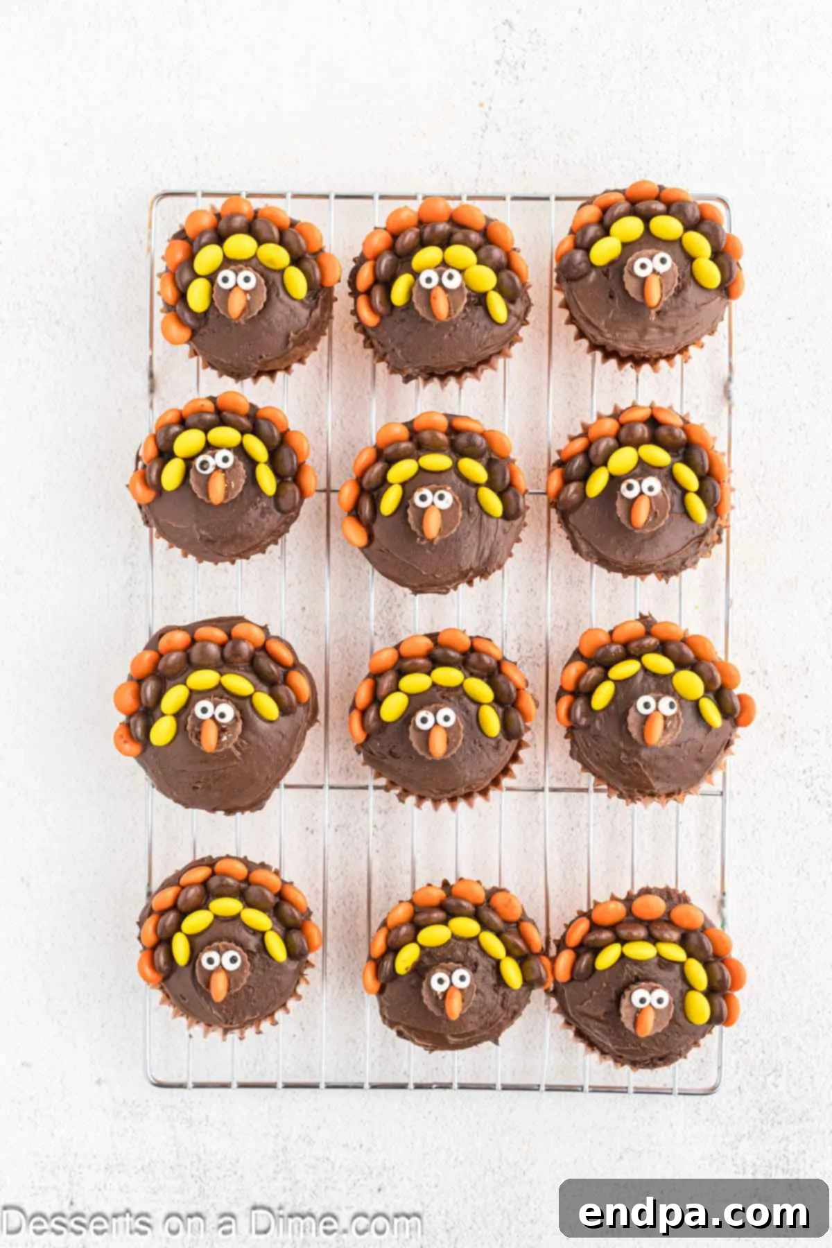 Cupcakes featuring their turkey faces with candy eyes meticulously added above the noses.