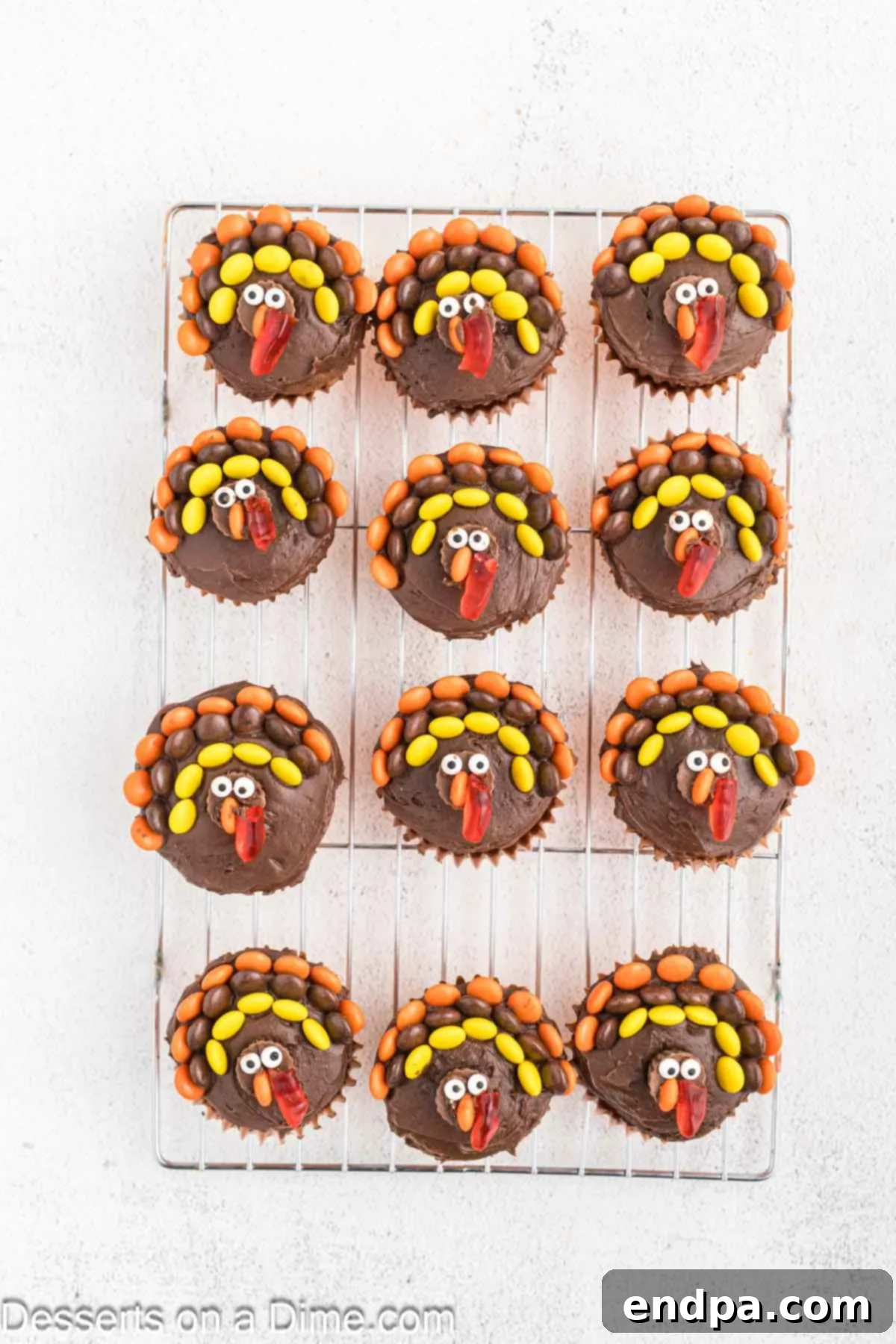 Cupcakes now complete with red gummy worm halves placed next to the noses to form the turkey's wattle.
