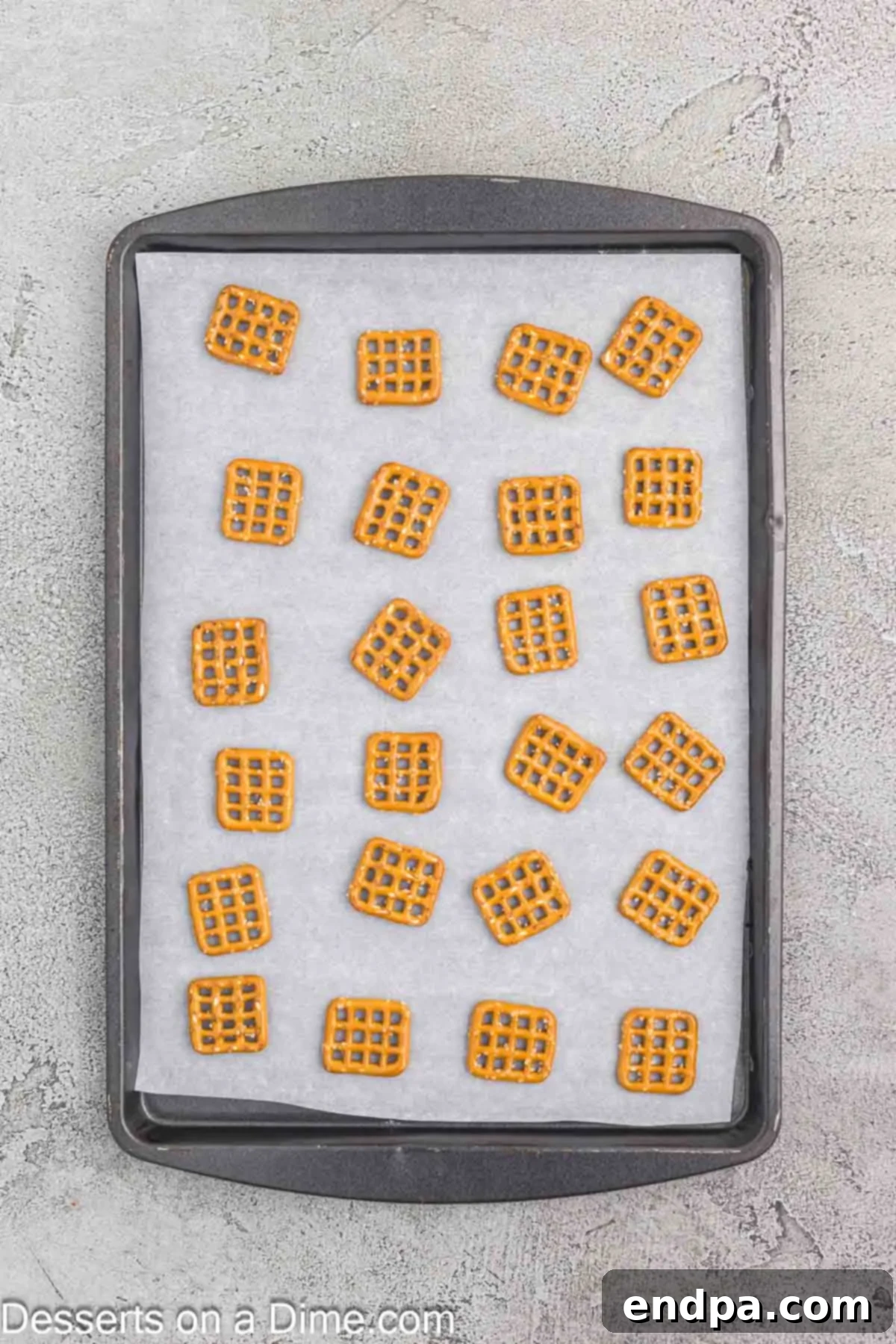 Pretzels arranged neatly on a baking sheet lined with parchment paper.