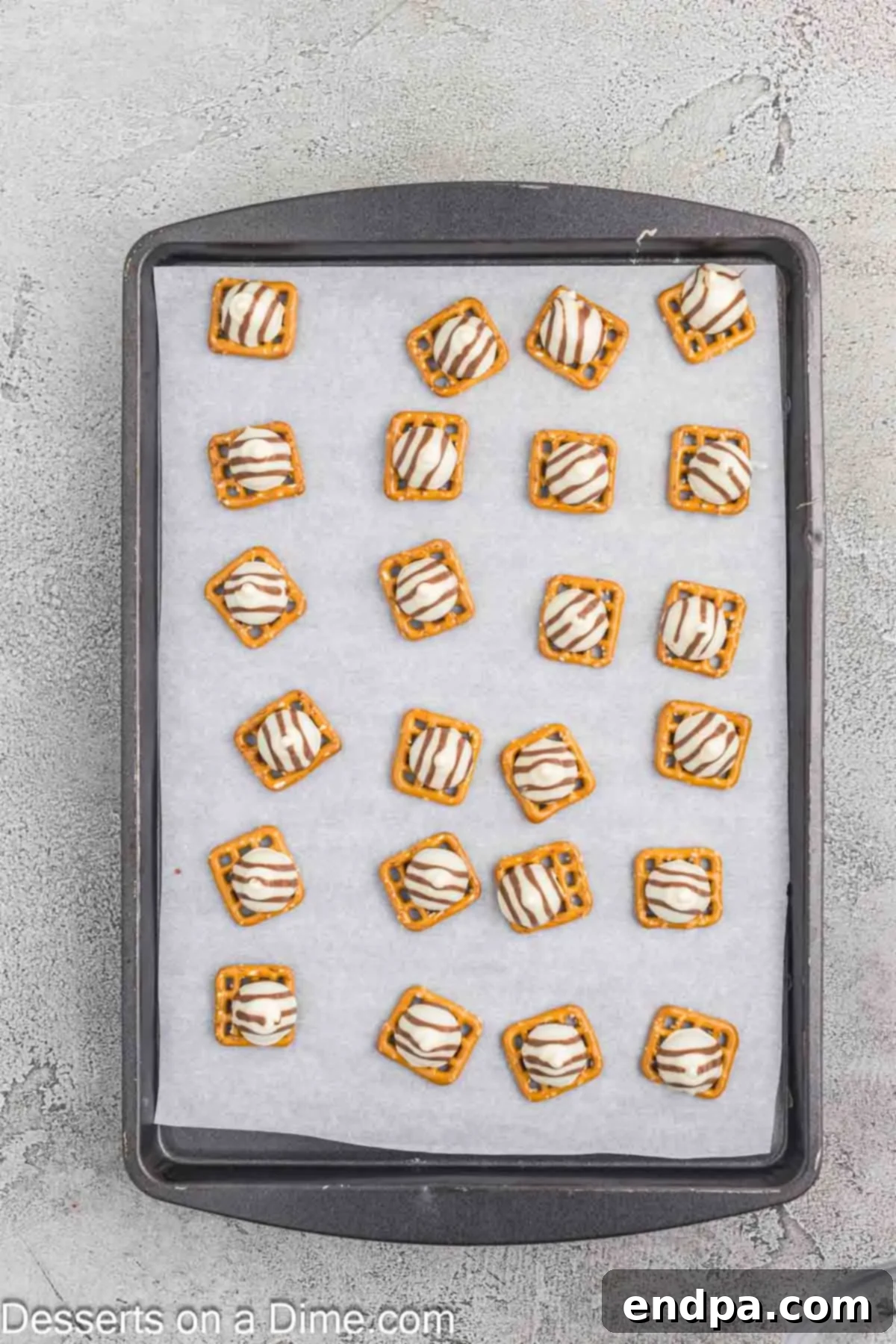 Melted Hershey Hugs candies on pretzels, slightly flattened.