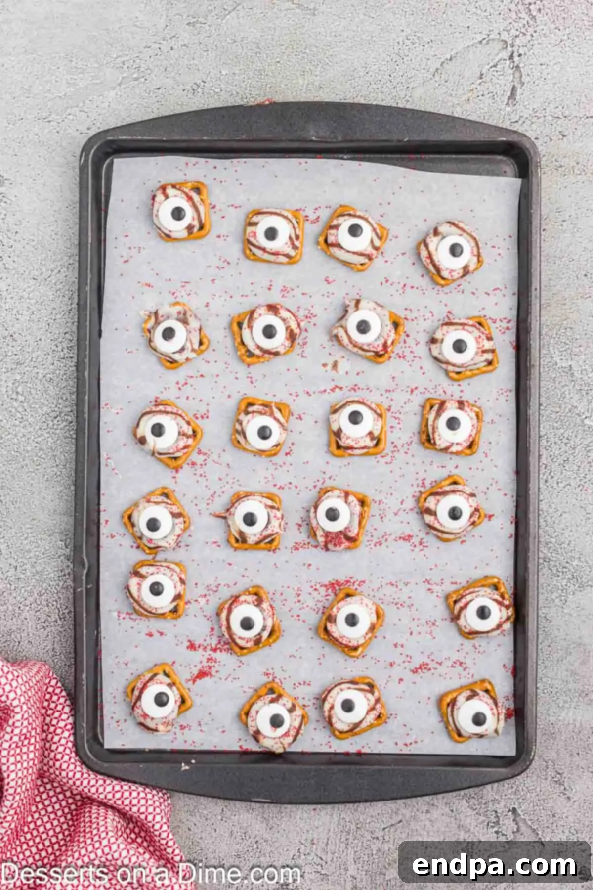 Candy eyeballs gently pressed into the center of each melted chocolate on pretzels.