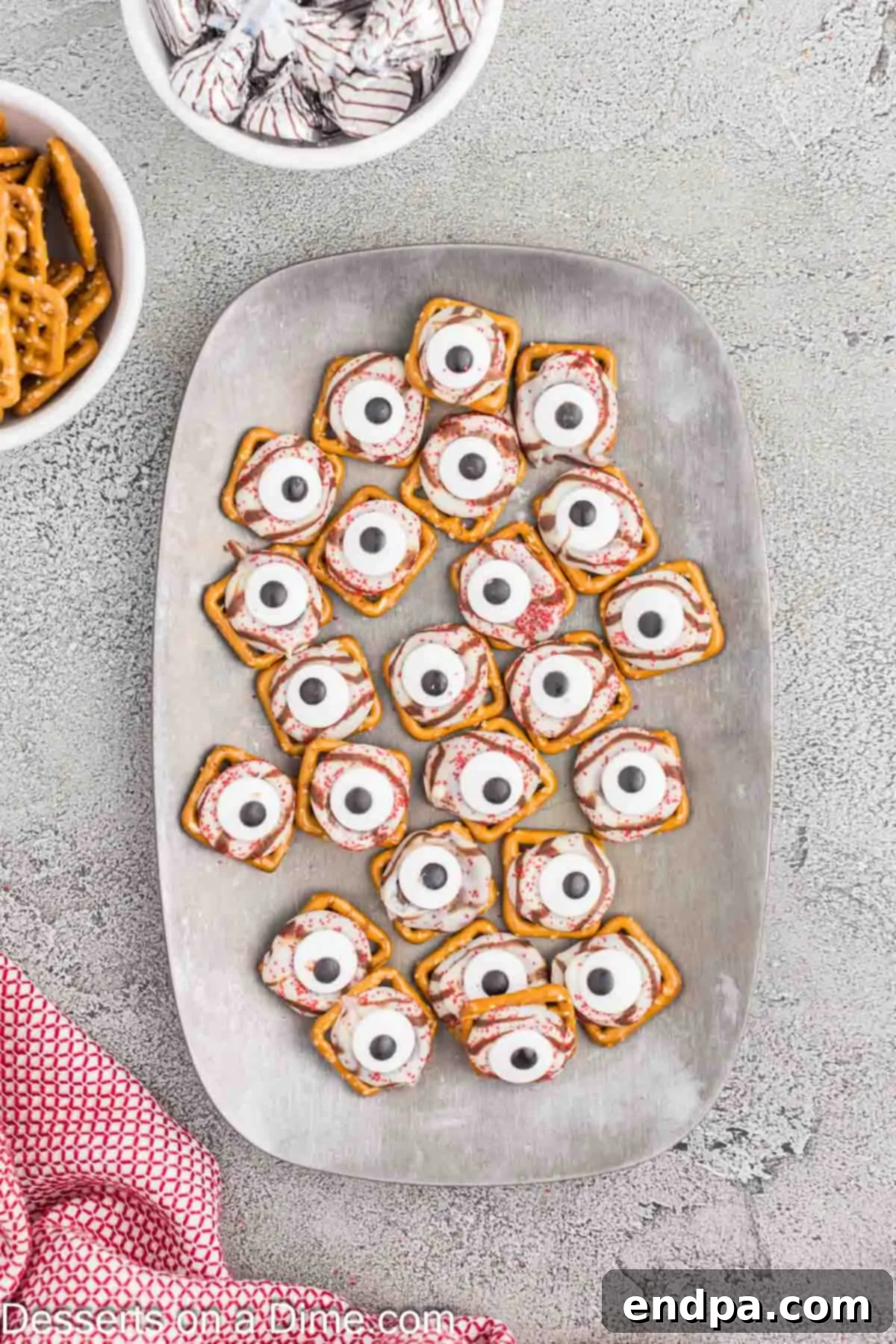 Finished monster eyeball pretzels cooling on a platter.