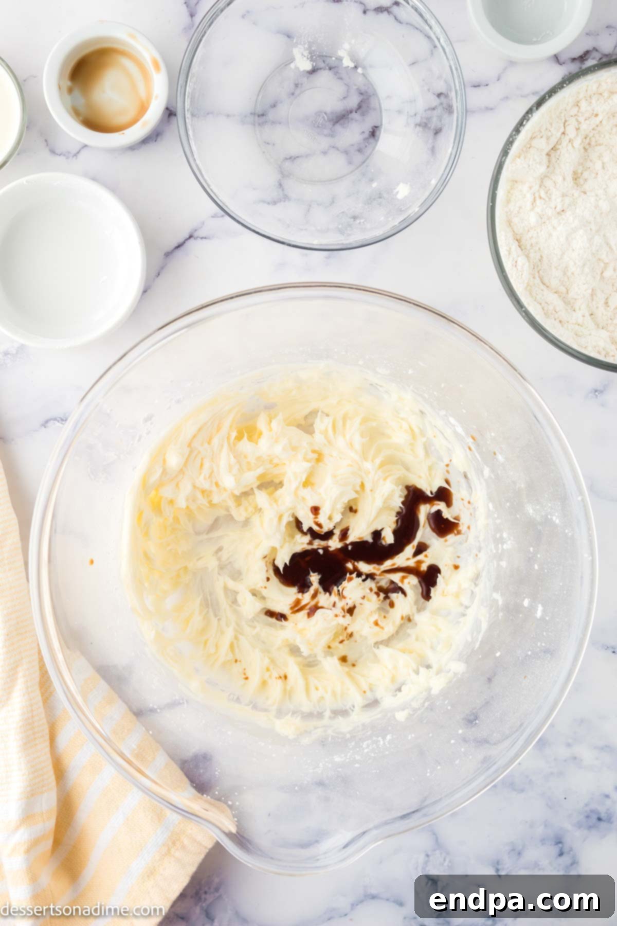 Butter, powdered sugar, and vanilla extract creamed together in a mixing bowl.