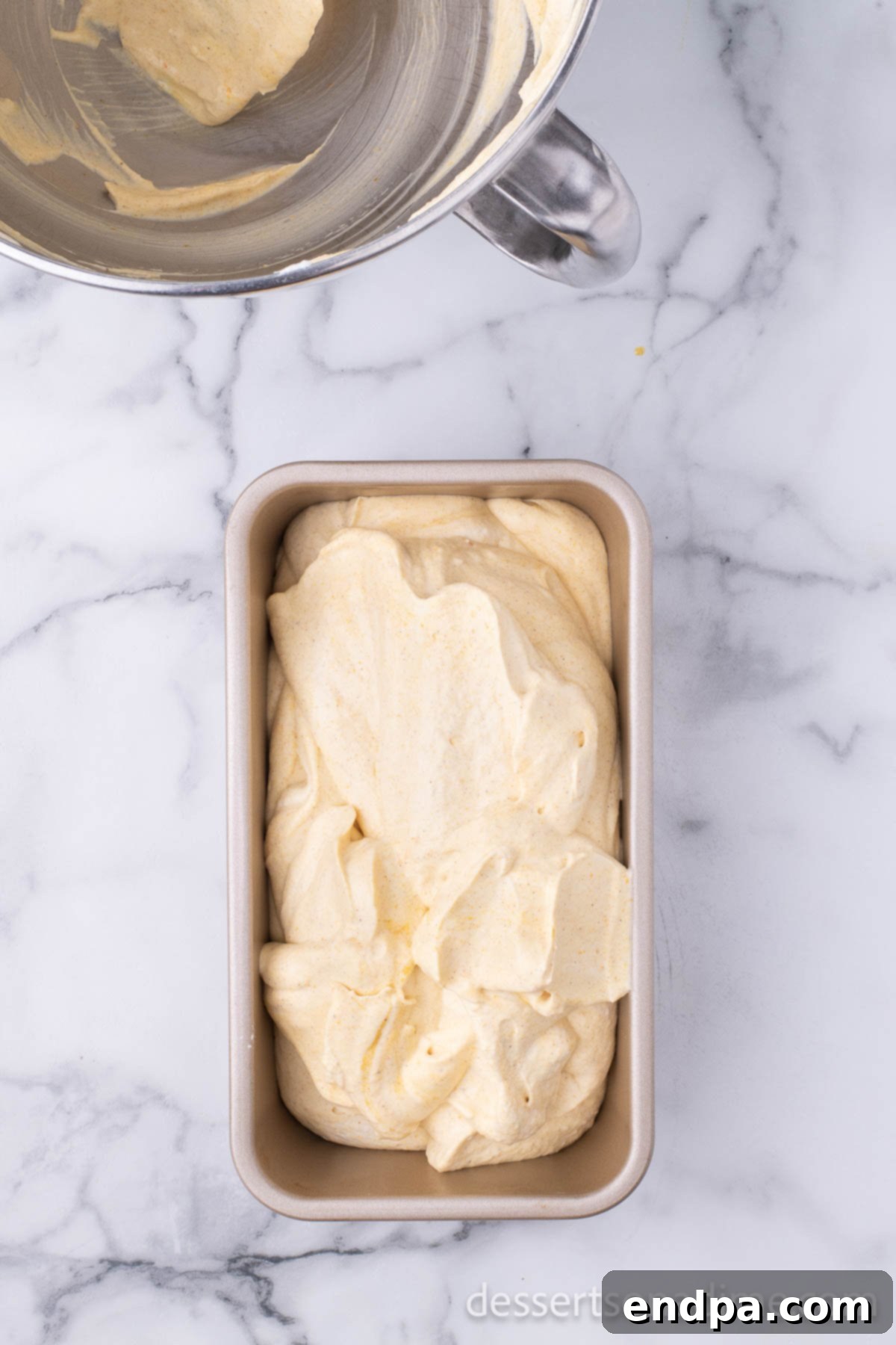 The smoothly combined pumpkin ice cream mixture spread evenly into a loaf pan, ready for freezing.