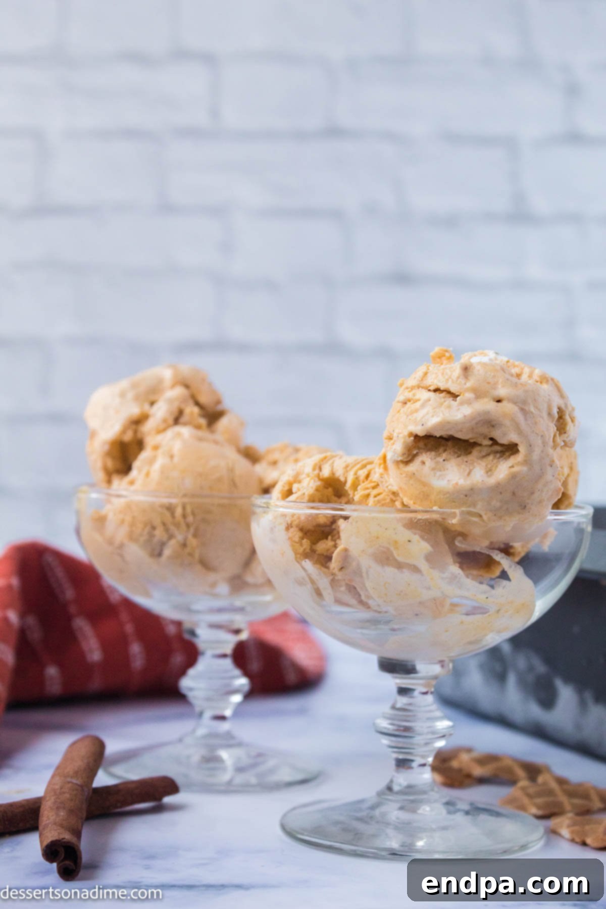 A close-up shot of a bowl filled with creamy pumpkin ice cream, topped with a delicate swirl of whipped cream and a sprinkle of cinnamon.