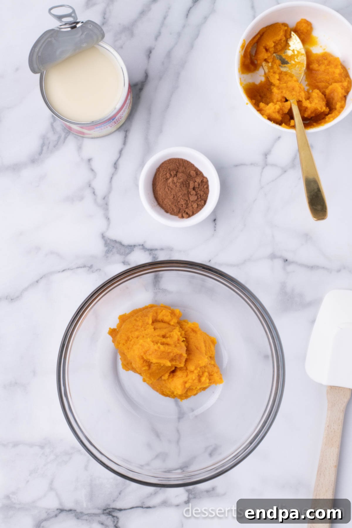 A separate large mixing bowl containing pure pumpkin puree, ready for combining with other ingredients.