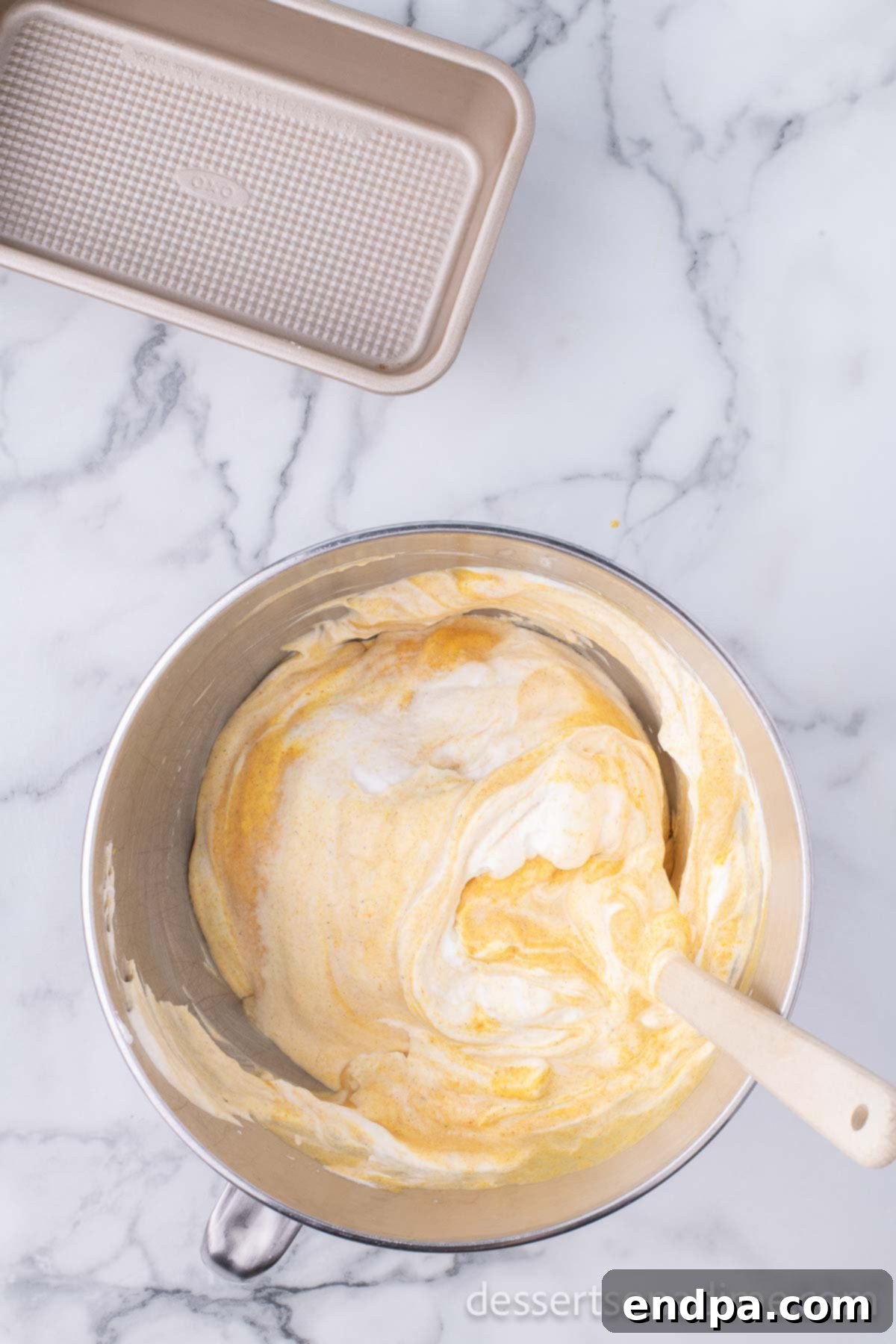 The pumpkin ice cream mixture, fully combined and smooth, ready to be transferred to a loaf pan for freezing.