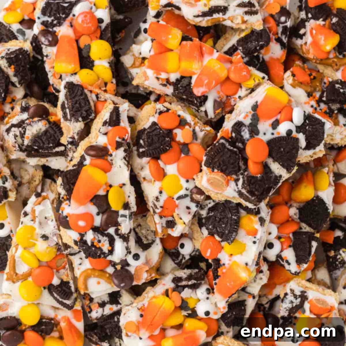 A pile of halloween candy bark with candy corn, chocolate chips and sprinkles.