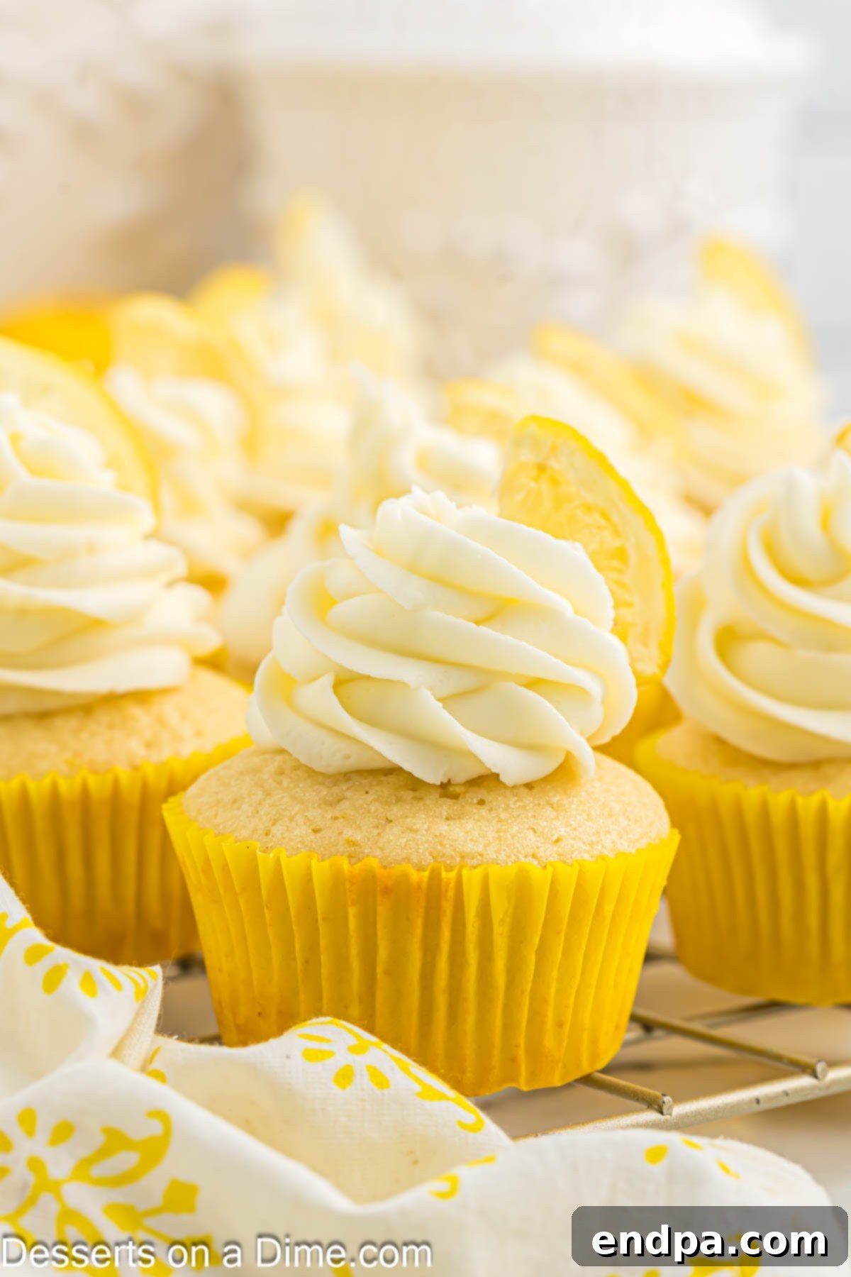 Beautifully frosted lemon cupcakes ready to be served on a white plate, garnished with lemon zest.