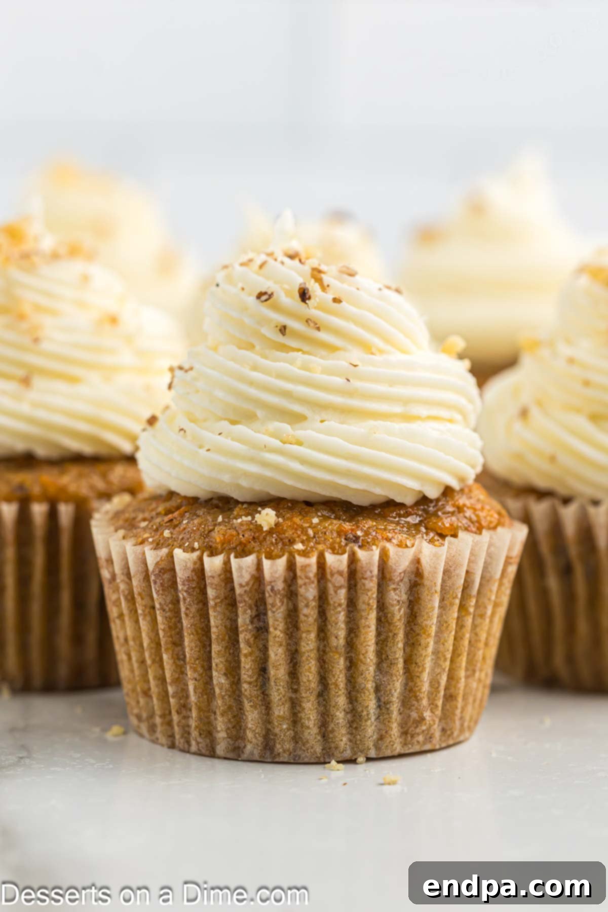 Irresistible Carrot Cake Cupcakes 2 Delicious Carrot Cake Cupcakes topped with cream cheese frosting and walnuts.