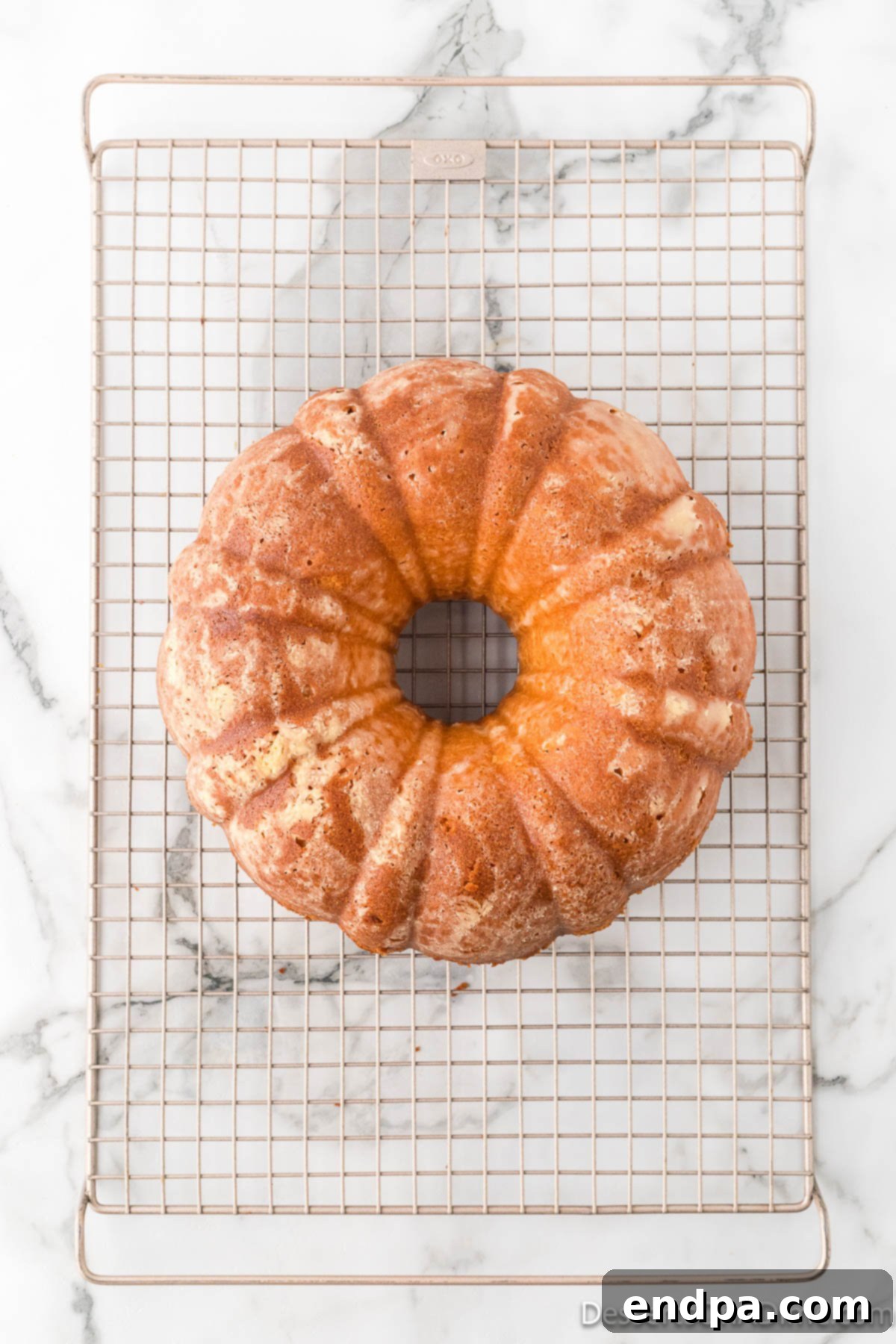Dreamy Cream Cheese Pound Cake 15 A perfectly formed cream cheese pound cake rests on a wire rack, cooling completely after being removed from the pan, ready to be sliced and served.