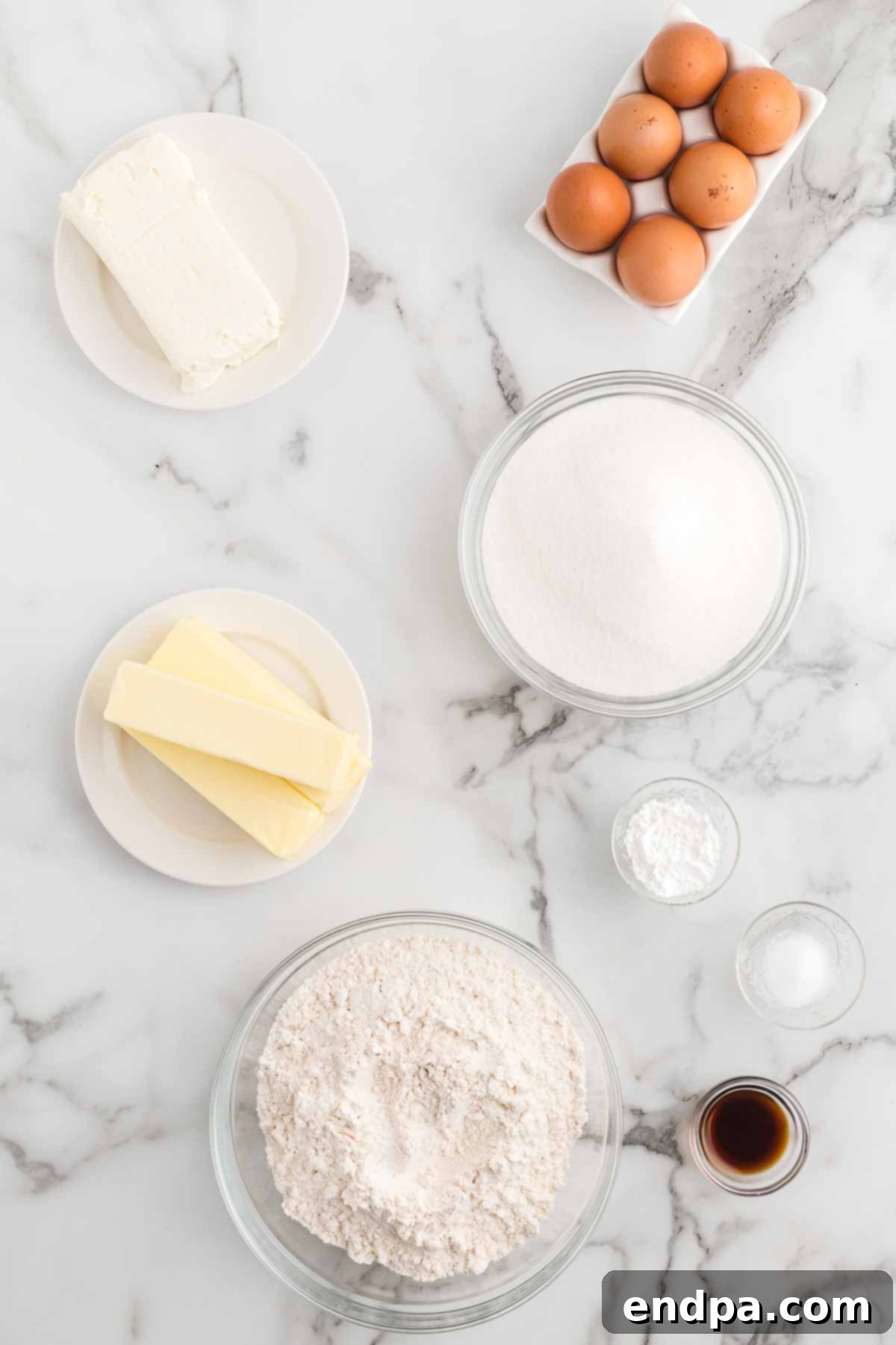 Dreamy Cream Cheese Pound Cake 3 A collection of essential ingredients for Cream Cheese Pound Cake: softened unsalted butter, full-fat cream cheese, fresh eggs, fragrant vanilla extract, and all-purpose flour, neatly arranged for baking.