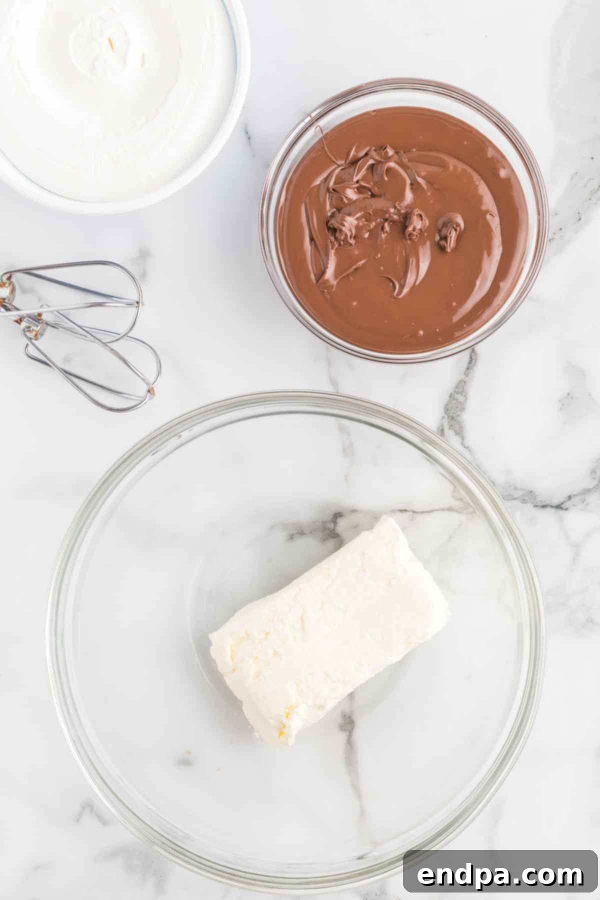 Softened cream cheese in a mixing bowl, ready to be beaten.