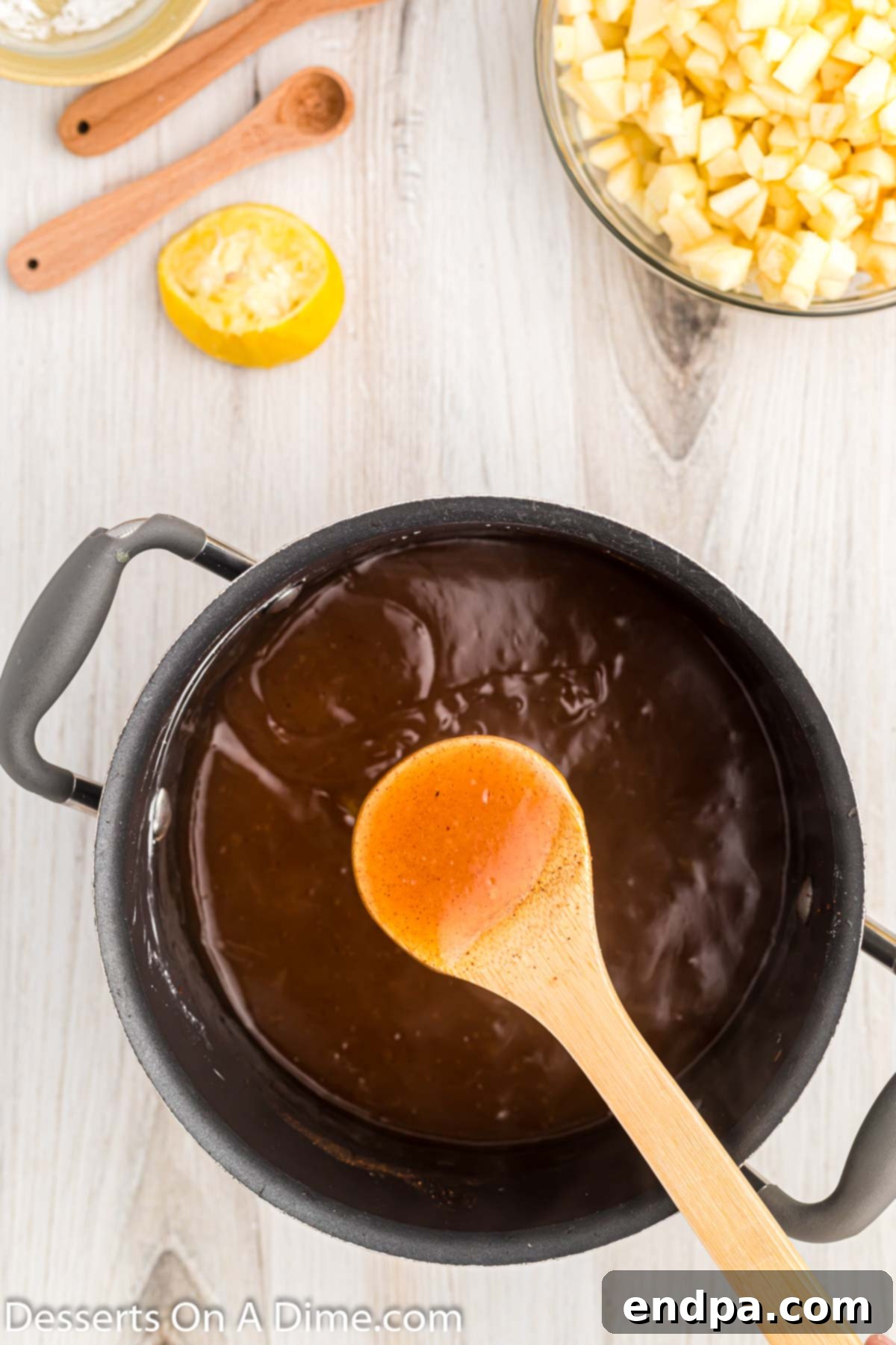 Close-up of the sugar and spice mixture gently simmering in a saucepan, beginning to thicken.