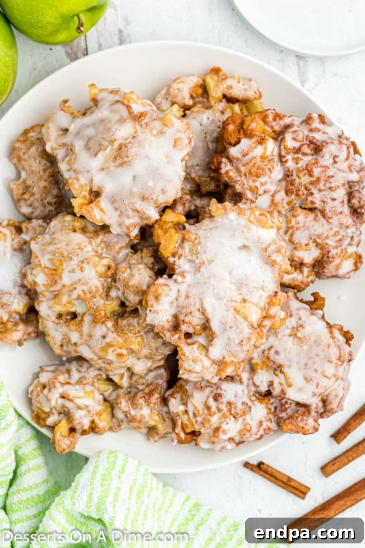 Golden Crisp Apple Fritters 2 Freshly made apple fritters on a white plate, ready to be served.