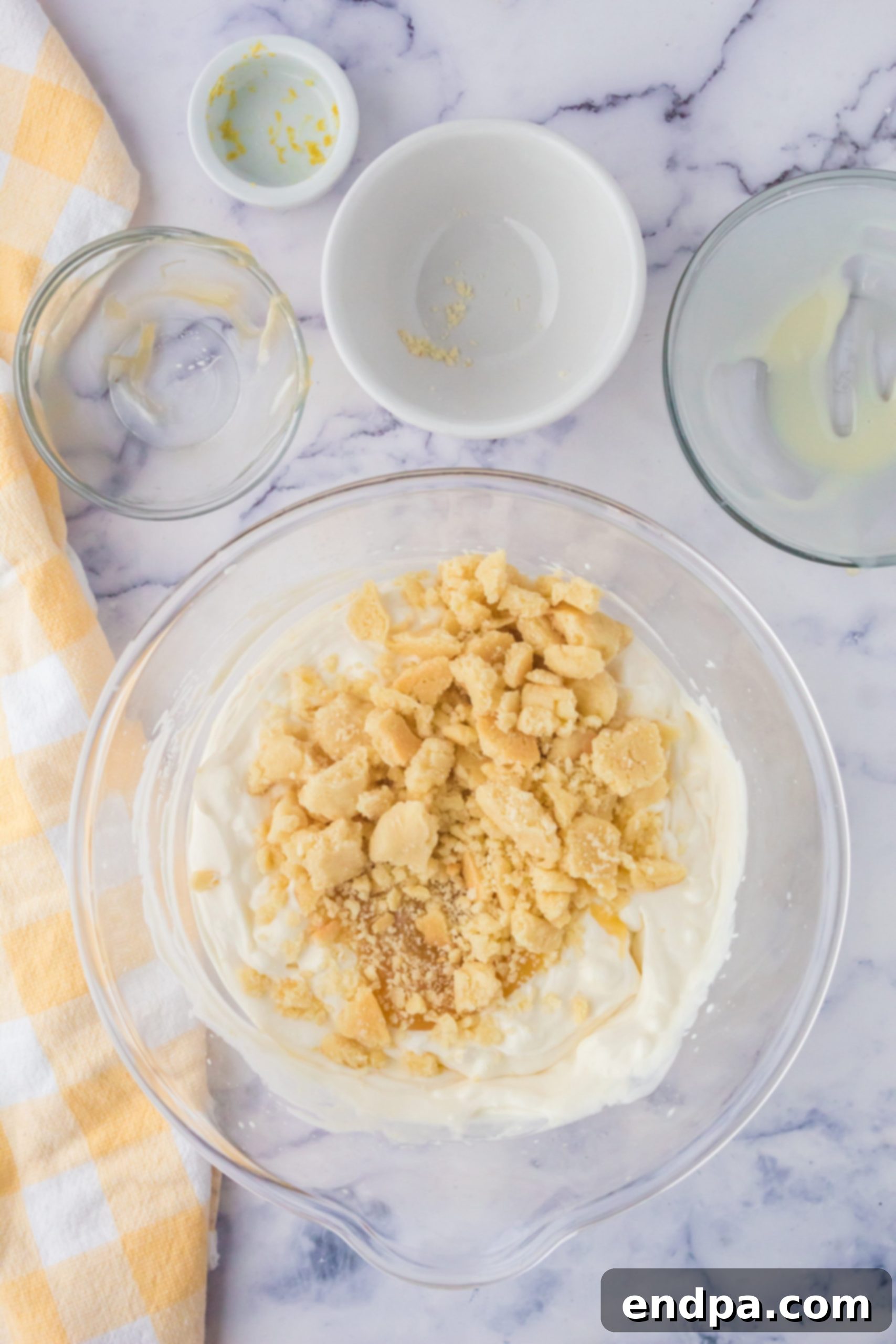 Zesty Shortbread Crumble Ice Cream 5 Crumbled shortbread cookies and lemon curd being swirled into the ice cream base.