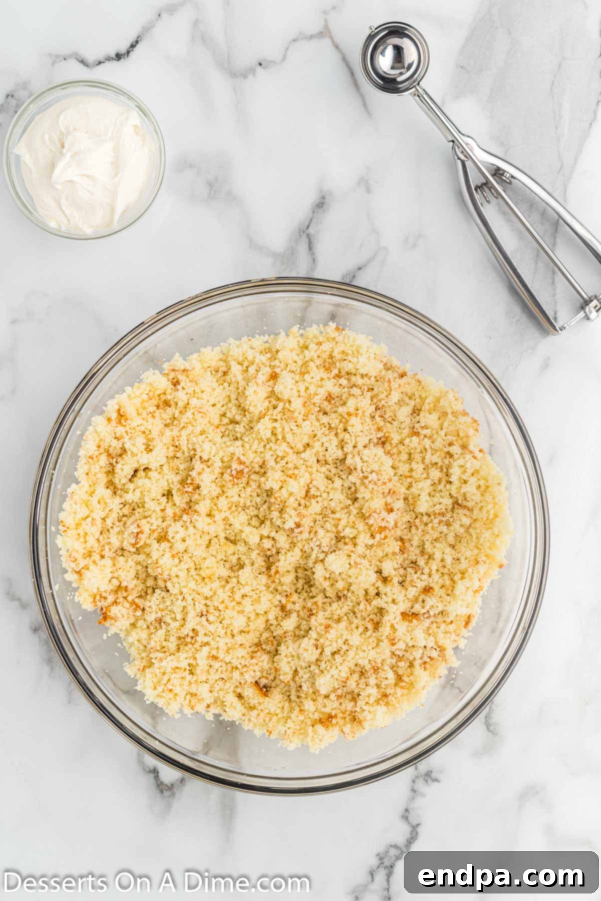 Cake crumbled finely in a large mixing bowl, ready to be combined with frosting.