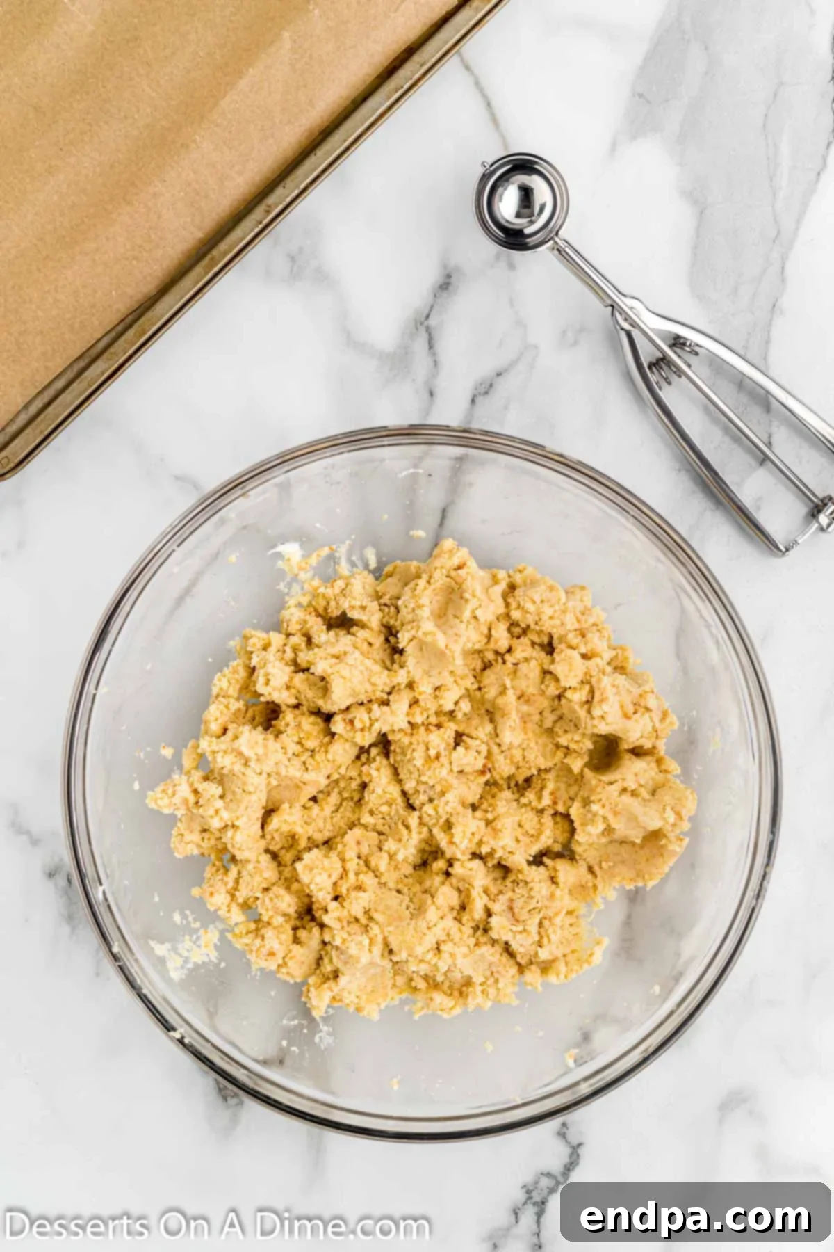 Crumbled cake and vanilla frosting thoroughly combined in a bowl, forming a dense, uniform mixture.