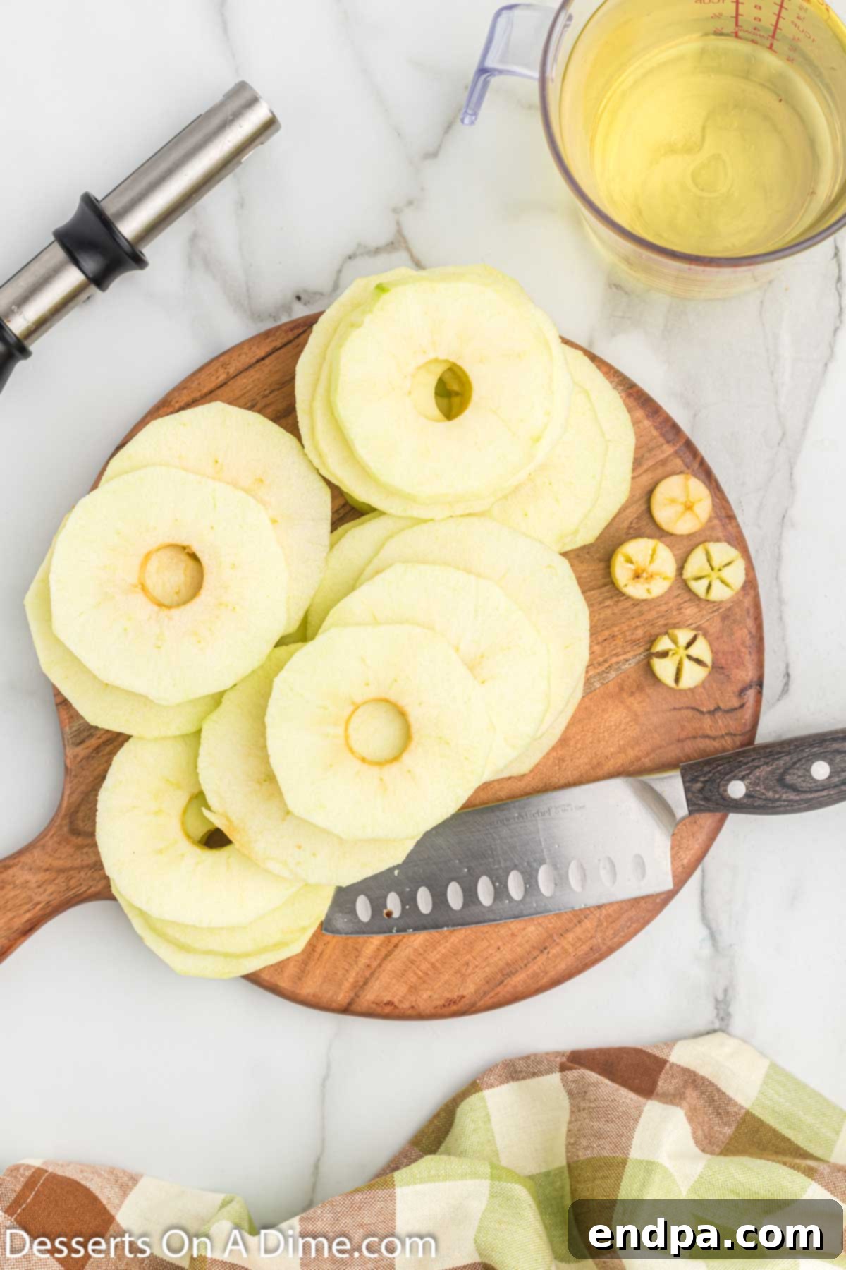 Apple slices laid out on a cutting board, ready for battering and frying.