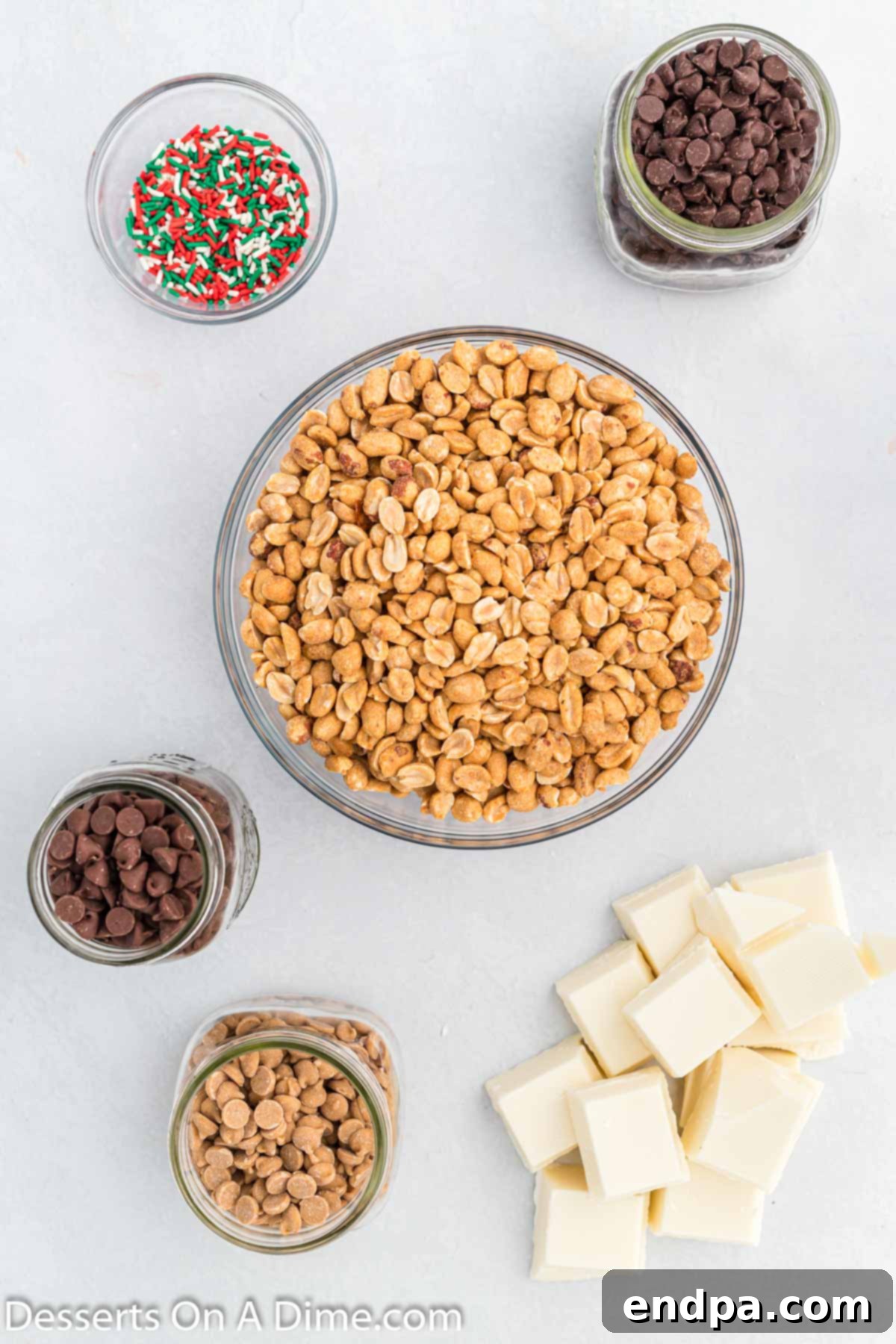 Ingredients for Crock pot Christmas candy- peanuts, chocolate, almond bark, sprinkles on a rustic wooden surface.